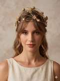 Casquete floral dorado con alambres y mariposas, usado sobre cabello castaño.