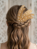 Peina de cabello dorada con hojas decorativas y puntas en un moño.
