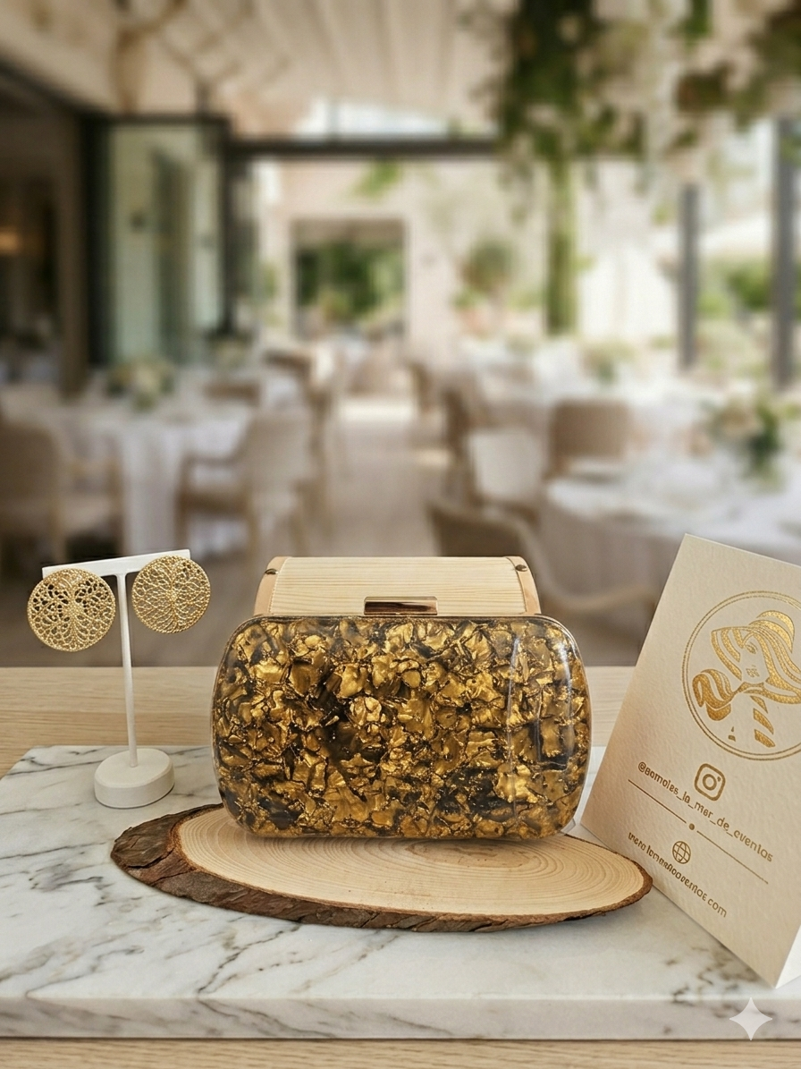 Bolso NY dorado con cierre metálico rectangular y asa corta, textura brillante