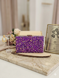 Bolso Bali de lentejuelas moradas con asa dorada y cierre superior