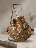 Bolso saco bordado con cuentas doradas y marrones, con cordón y borlas, sobre soporte
