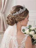 Tiara nupcial de pedrería plateada sobre peinado trenzado, con cabello recogido