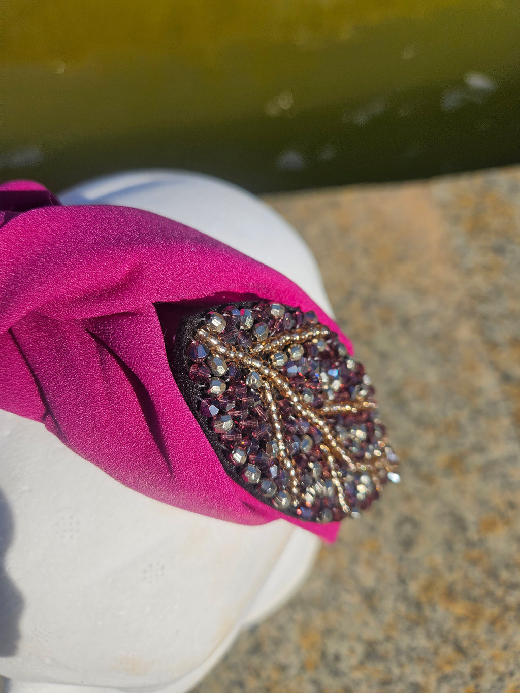 Diadema fucsia con pedrería oval negra y detalles metálicos brillantes