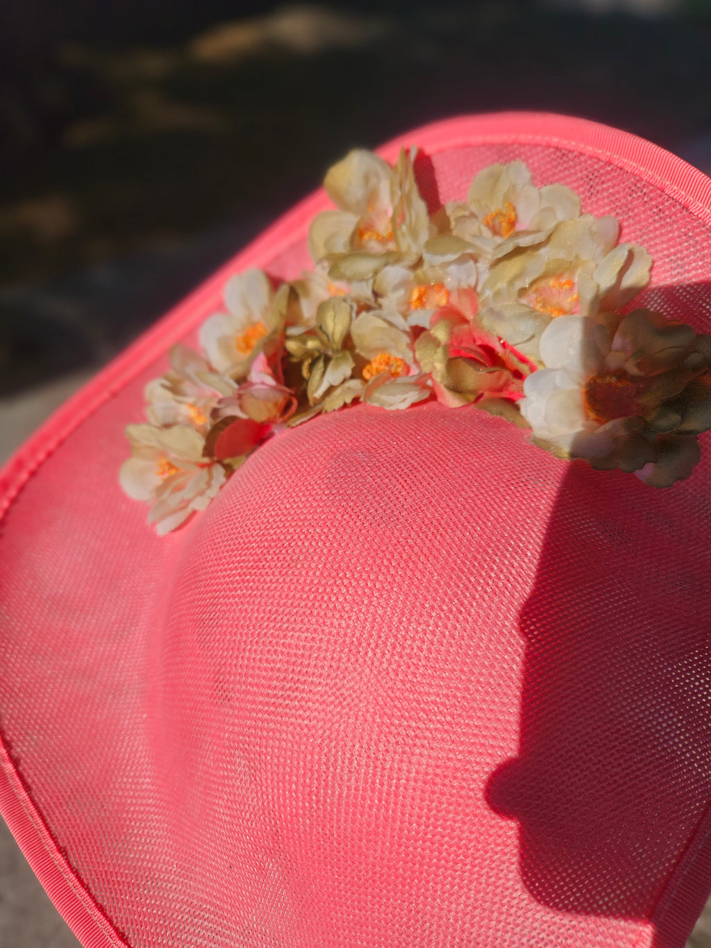 Pamela rosa con adorno floral crema y naranja en la copa, detalle