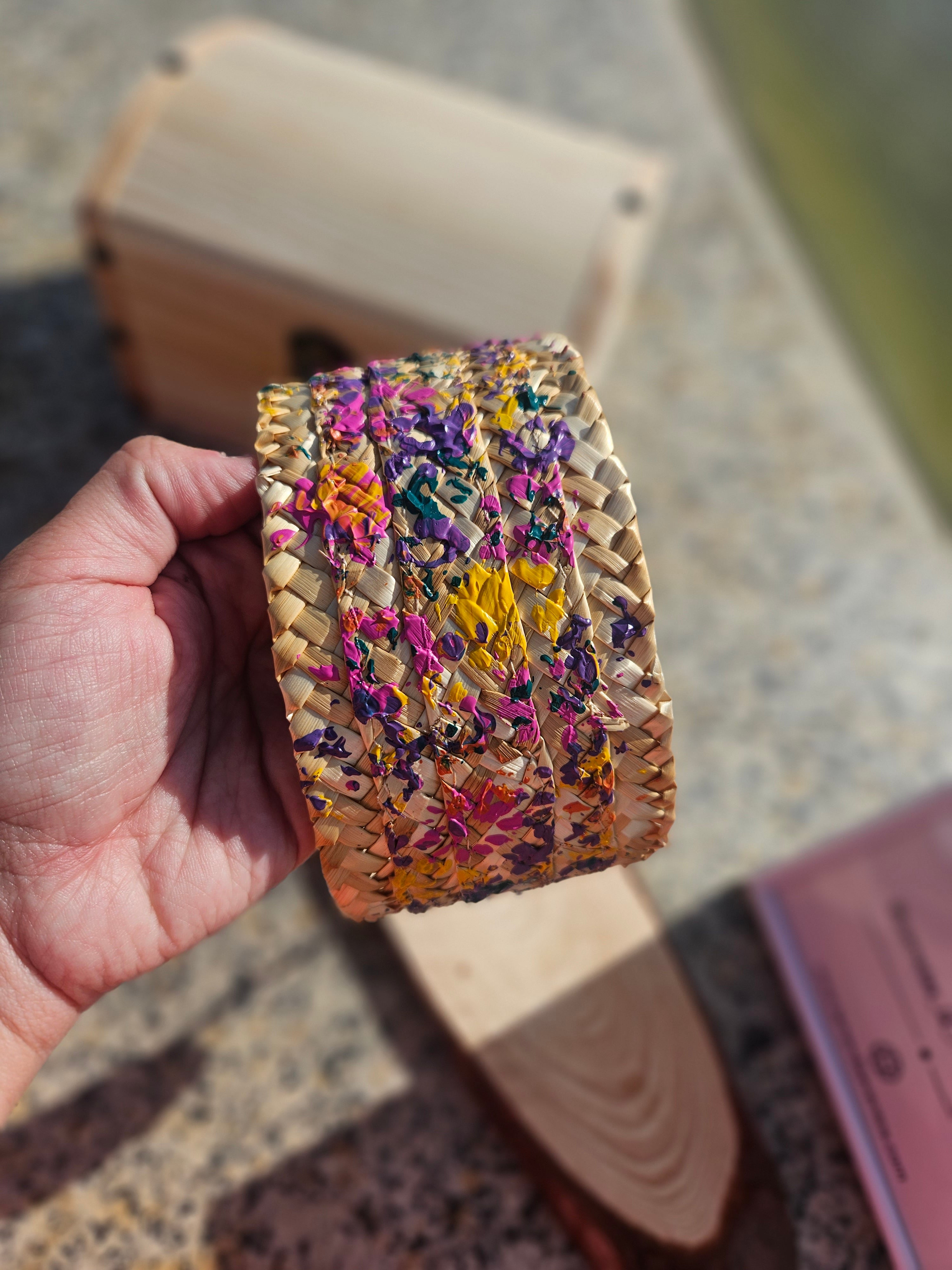 Diadema trenzada multicolor vista de cerca, fondo beige con detalles en amarillo y morado