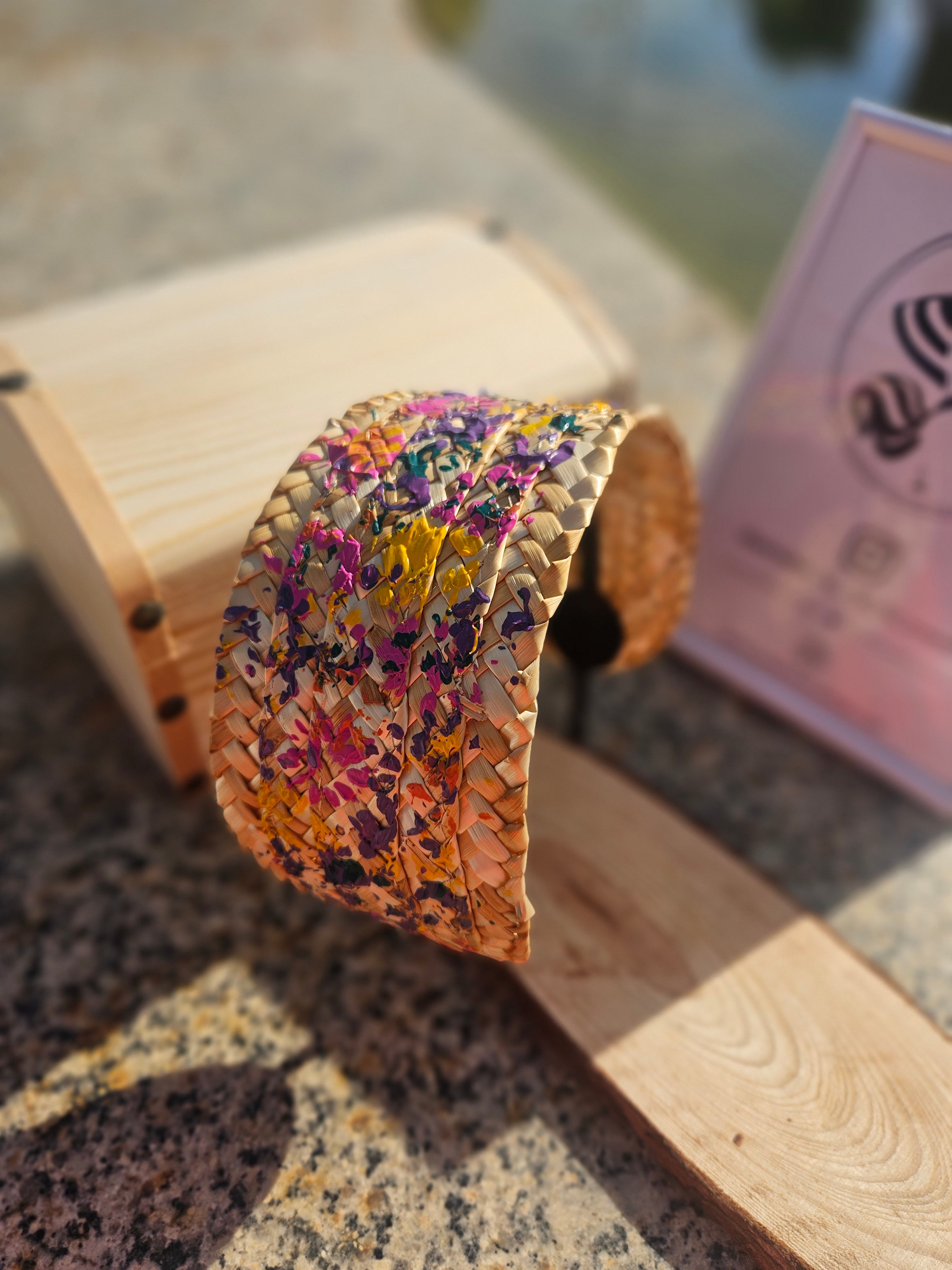 Diadema multicolor trenzada, colores morado, rosa y amarillo sobre base beige