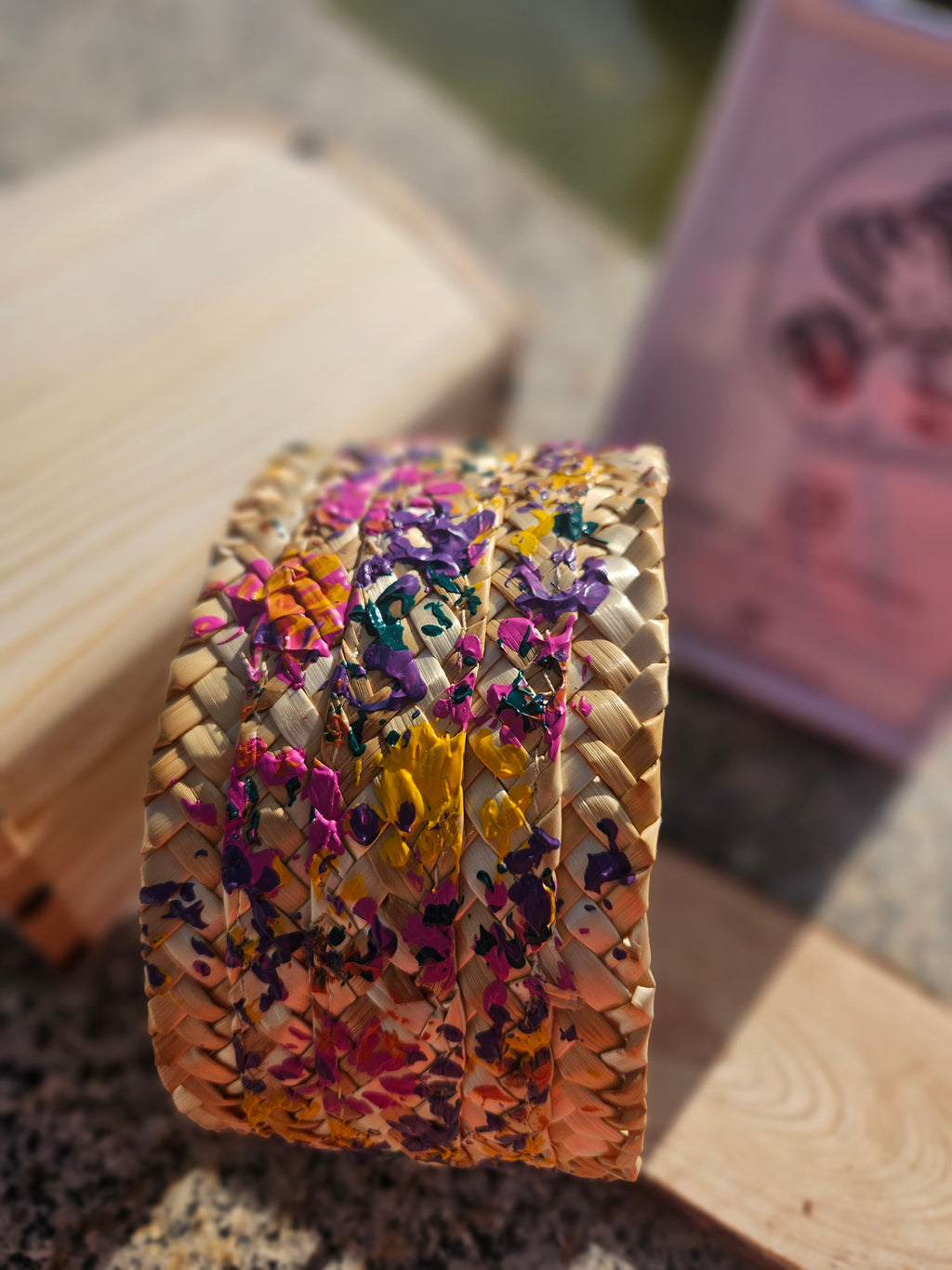 Diadema trenzada multicolor vista frontal, base beige con mezcla de tonos morados y amarillos
