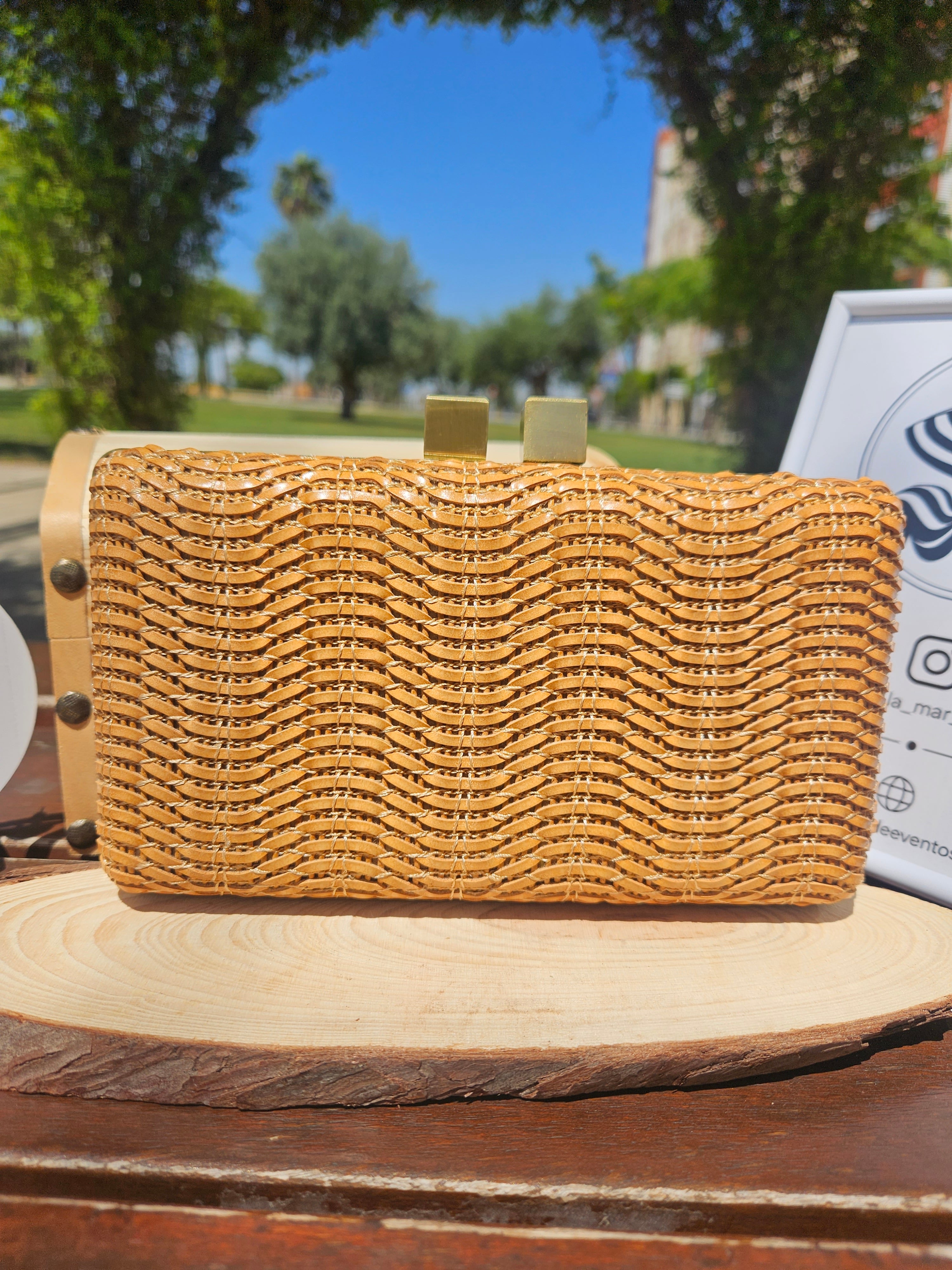 Bolso de paja tejido color beige con cierre y broches metálicos en la parte superior
