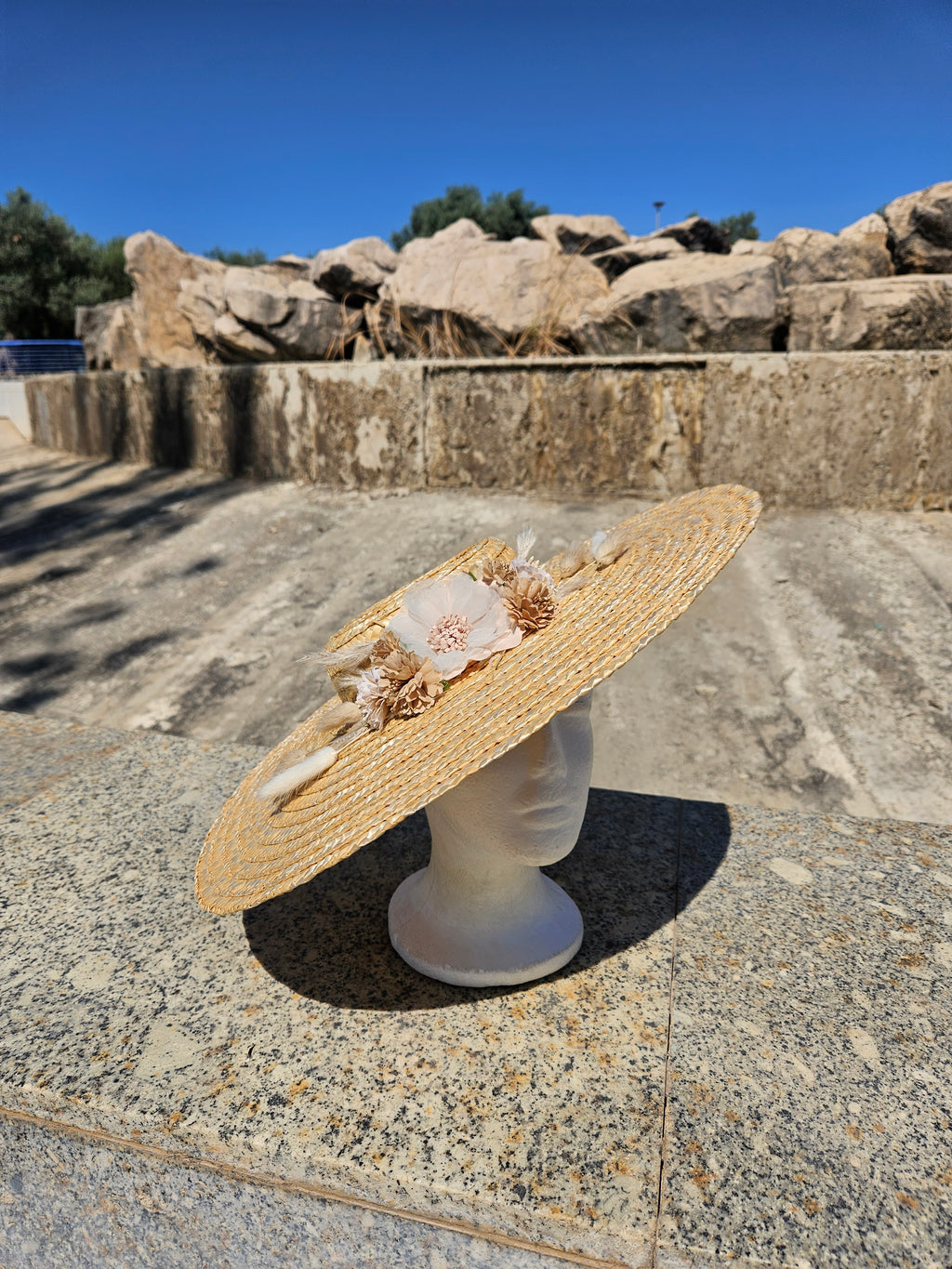 Sombrero de paja de ala grande con flores crema y cinta blanca en la banda