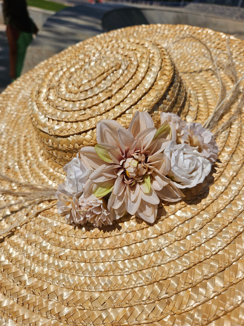 Sombrero de paja beige con gran flor blanca y detalles rosados en la copa