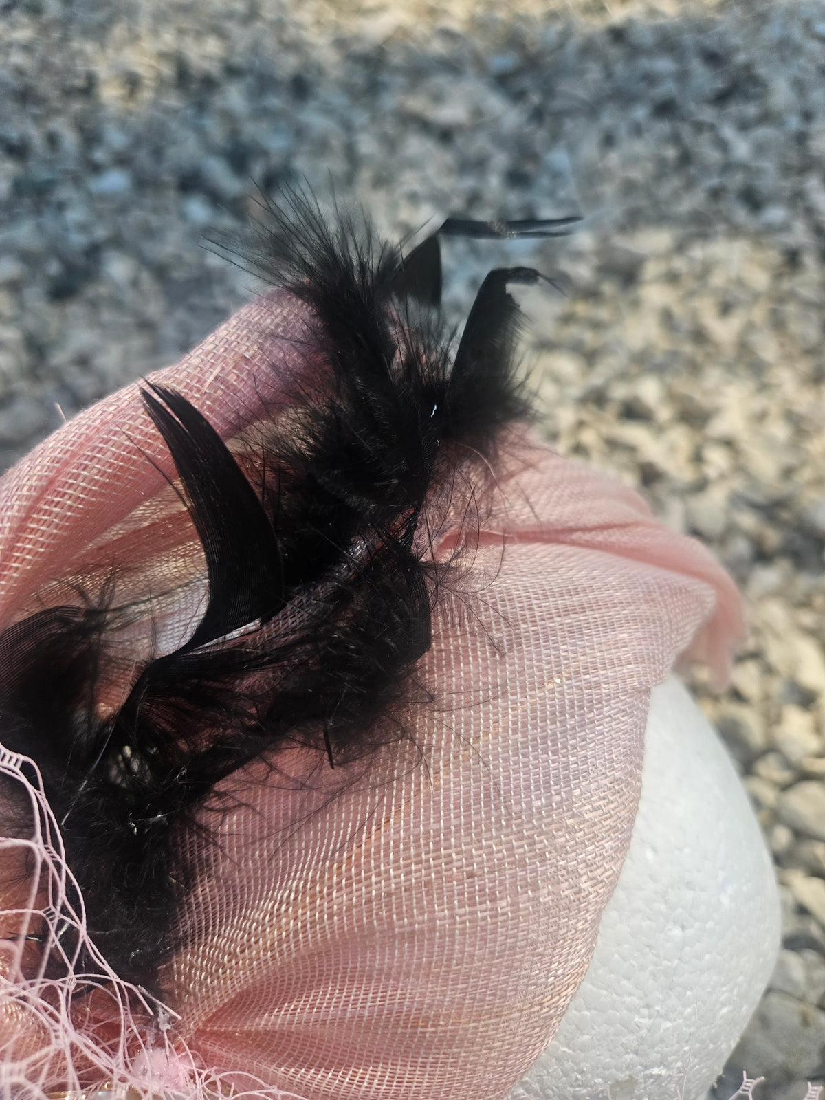 tocado Nandama rosa con pluma negra alta y velo de tul