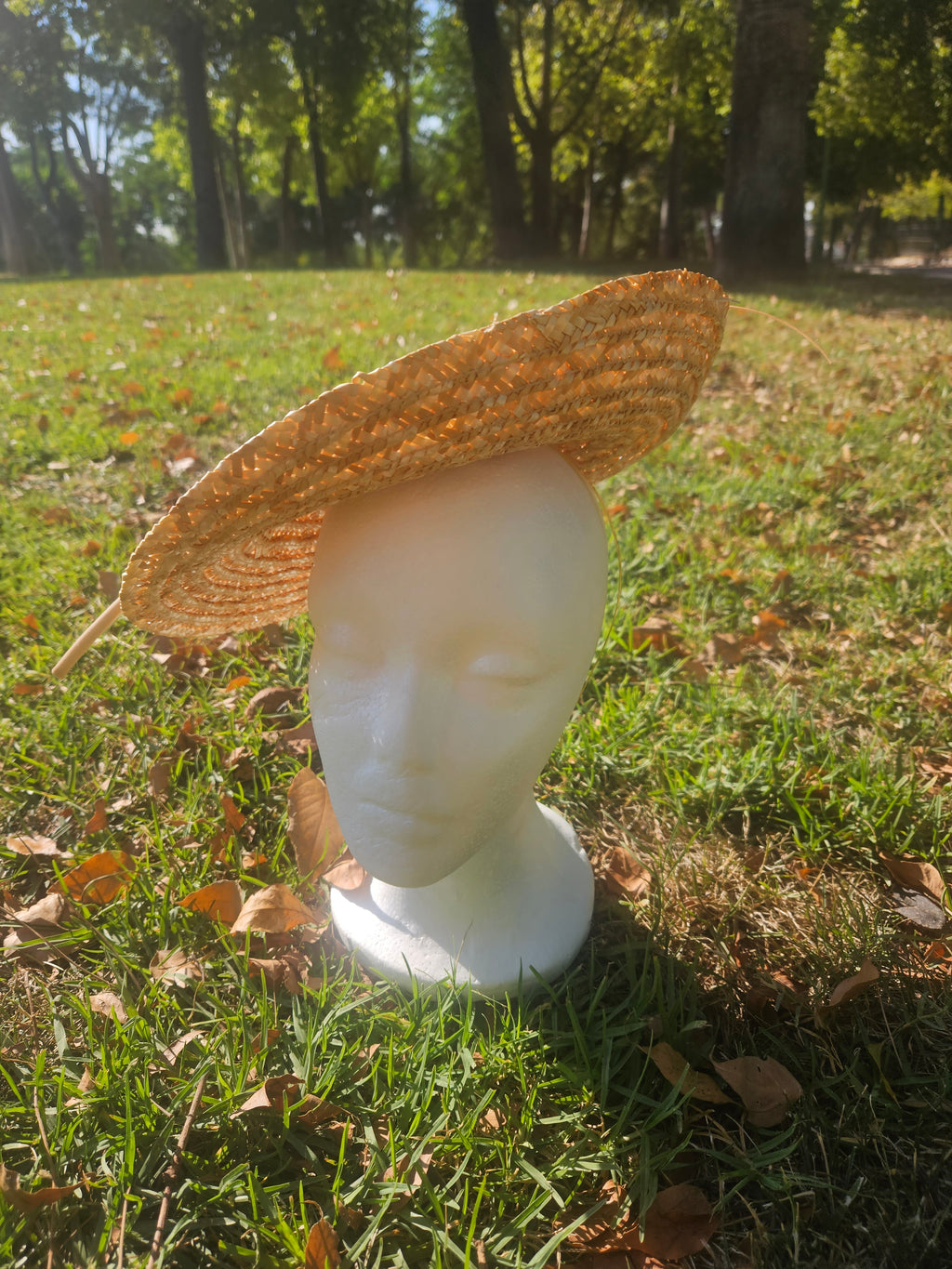 Sombrero tipo pamela de rafia beige con ala ancha y base en maniquí blanco