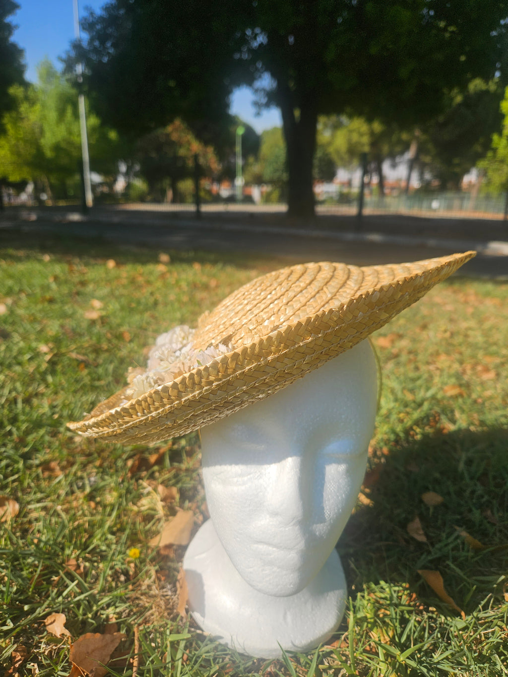 Sombrero de paja beige de ala ancha con flores blancas laterales