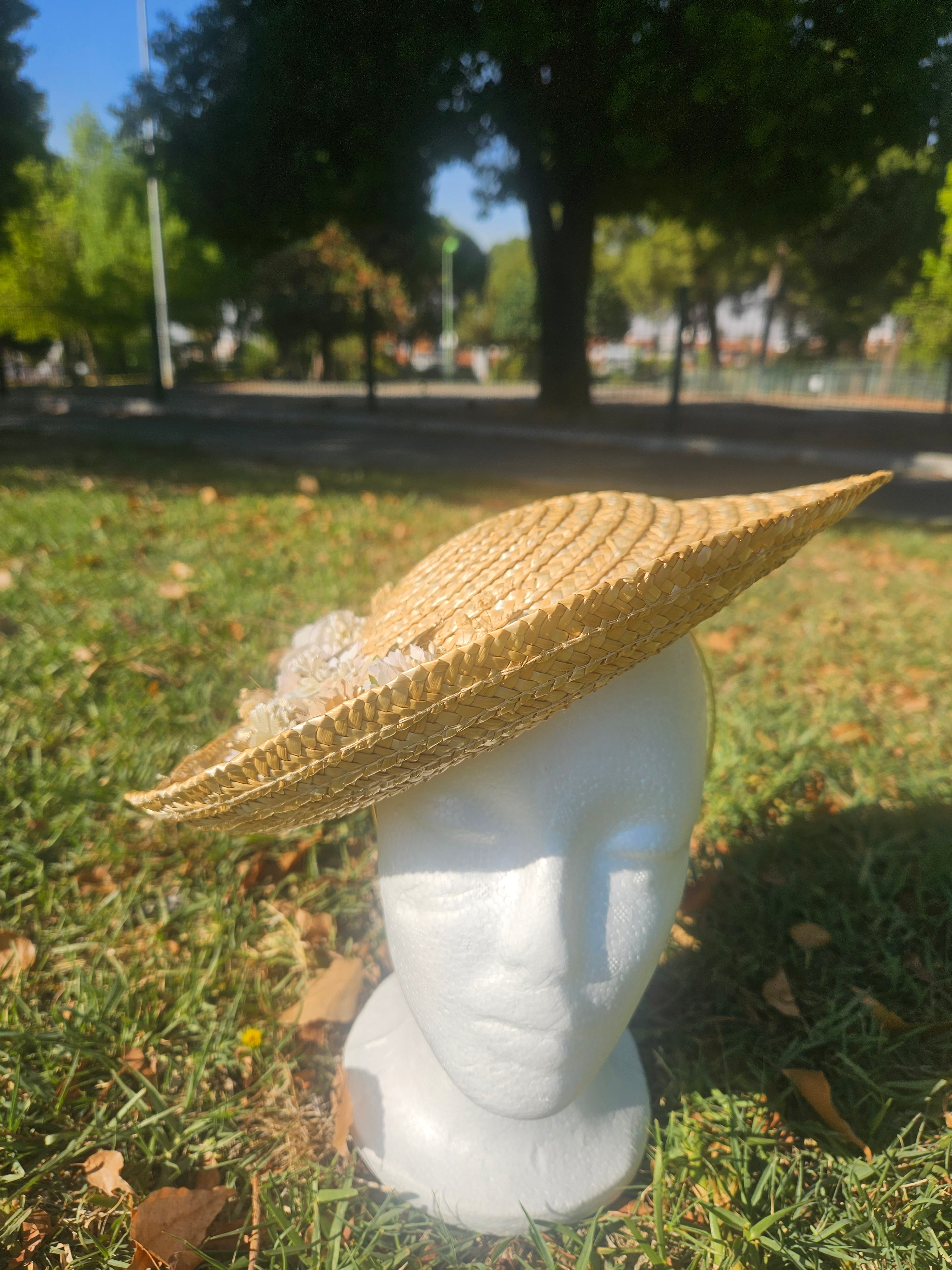 Sombrero de paja beige de ala ancha con flores blancas laterales