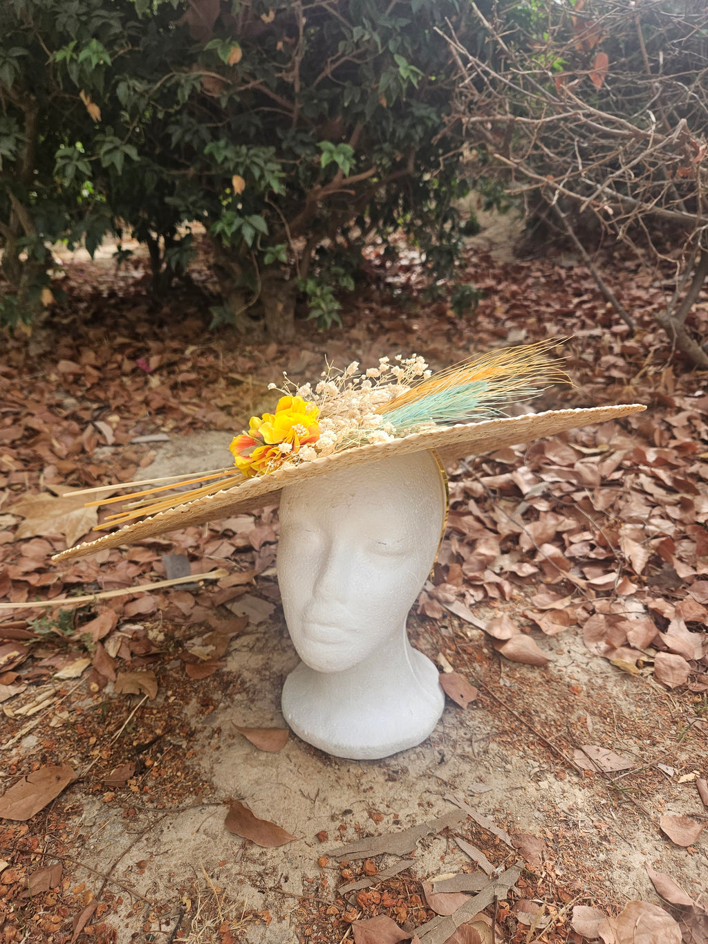 Sombrero de paja trenzada beige con ramo de flores amarillas y detalles turquesa