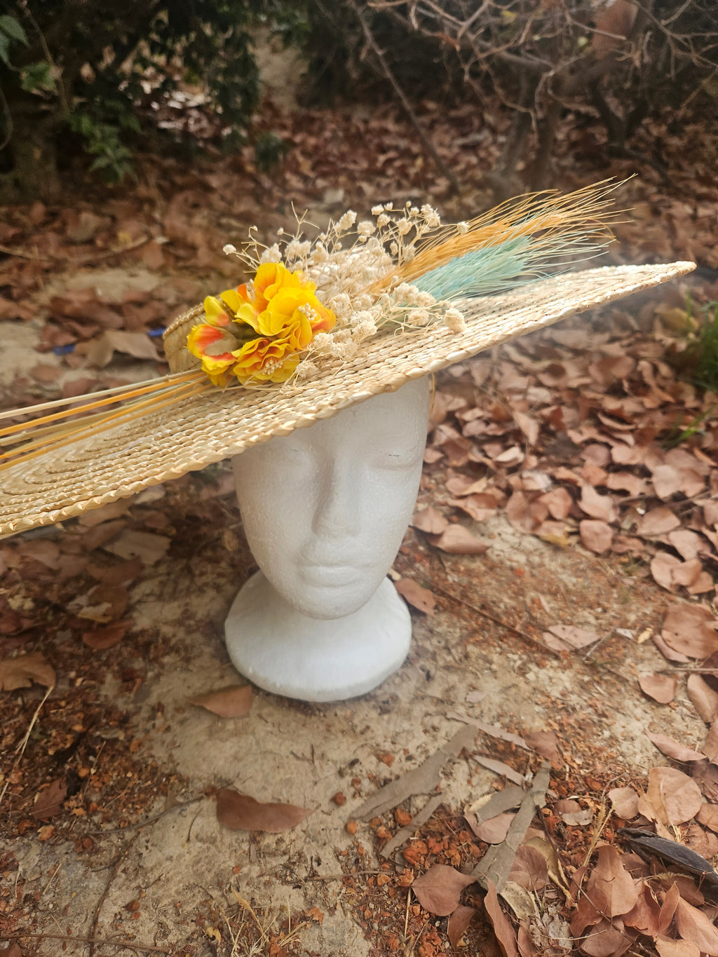 Sombrero de paja beige de ala ancha con flores amarillas y plumitas turquesa