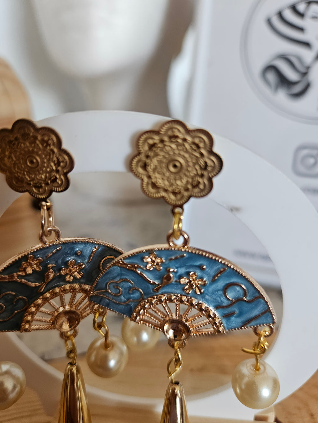 Pendientes con pieza floral dorada y aro azul con abanico, perlas colgantes.