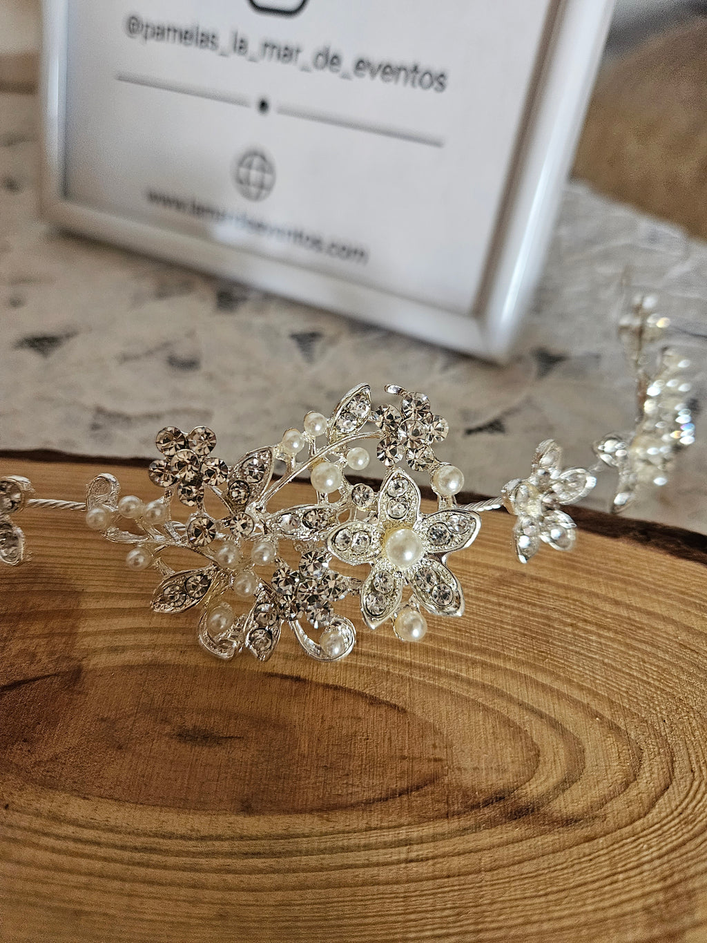 Tiara Denissa plateada con motivo central de flores y perlas tipo cristal, primer plano