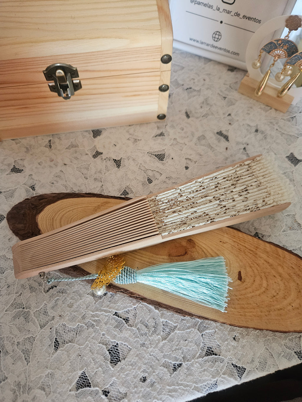 Abanico beige con borla turquesa y adorno dorado; varillas de madera y encaje