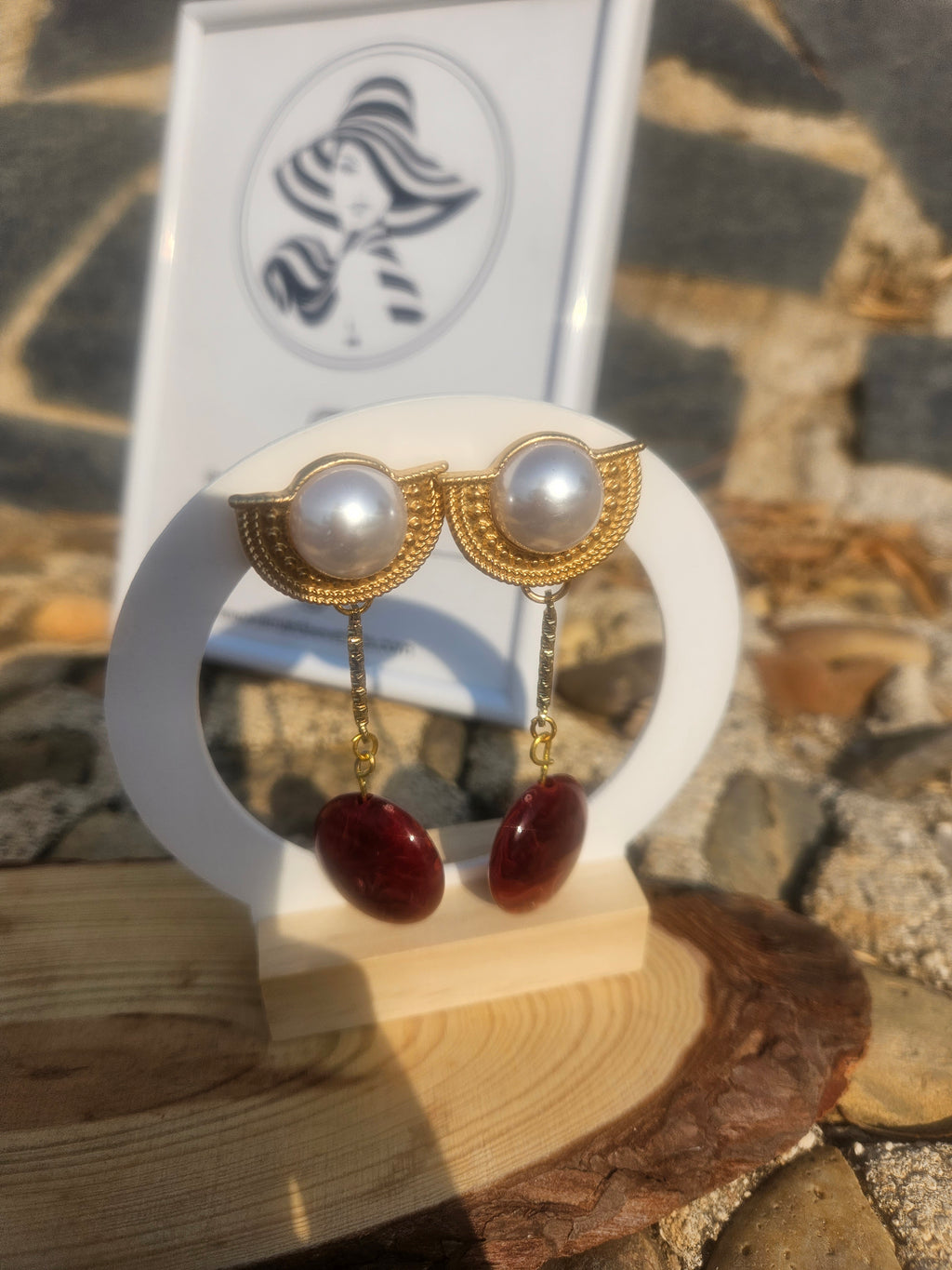 Pendientes con perlas blancas y gotas rojas, ganchos dorados y colgantes.