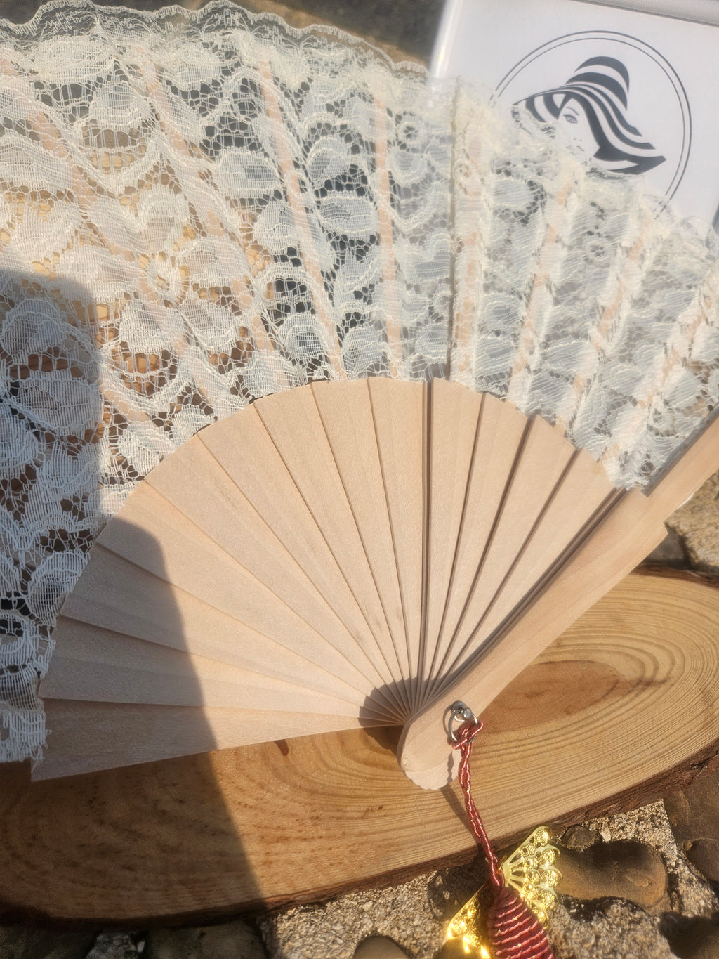 Abanico plegable de madera con encaje beige y borla granate colgante