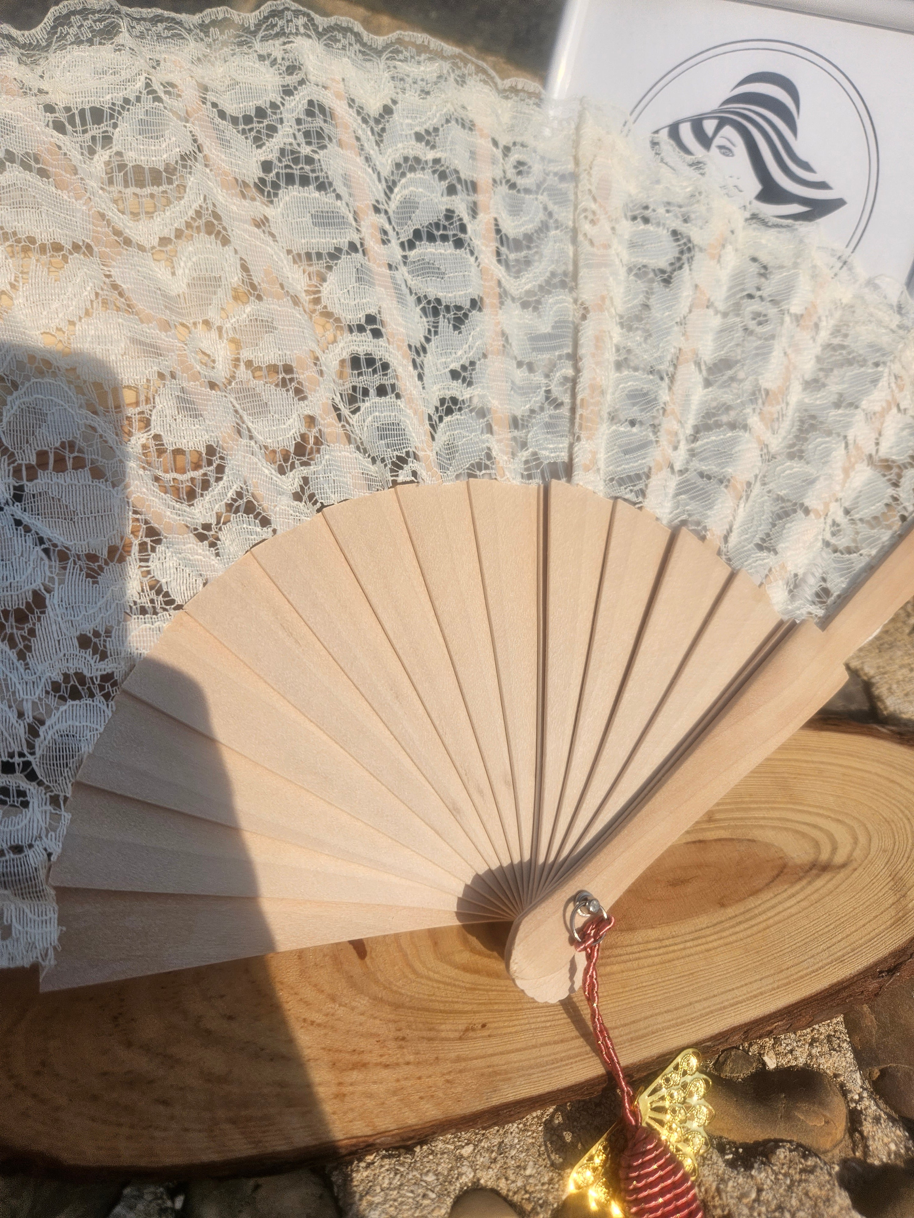 Abanico plegable de madera con encaje beige y borla granate colgante
