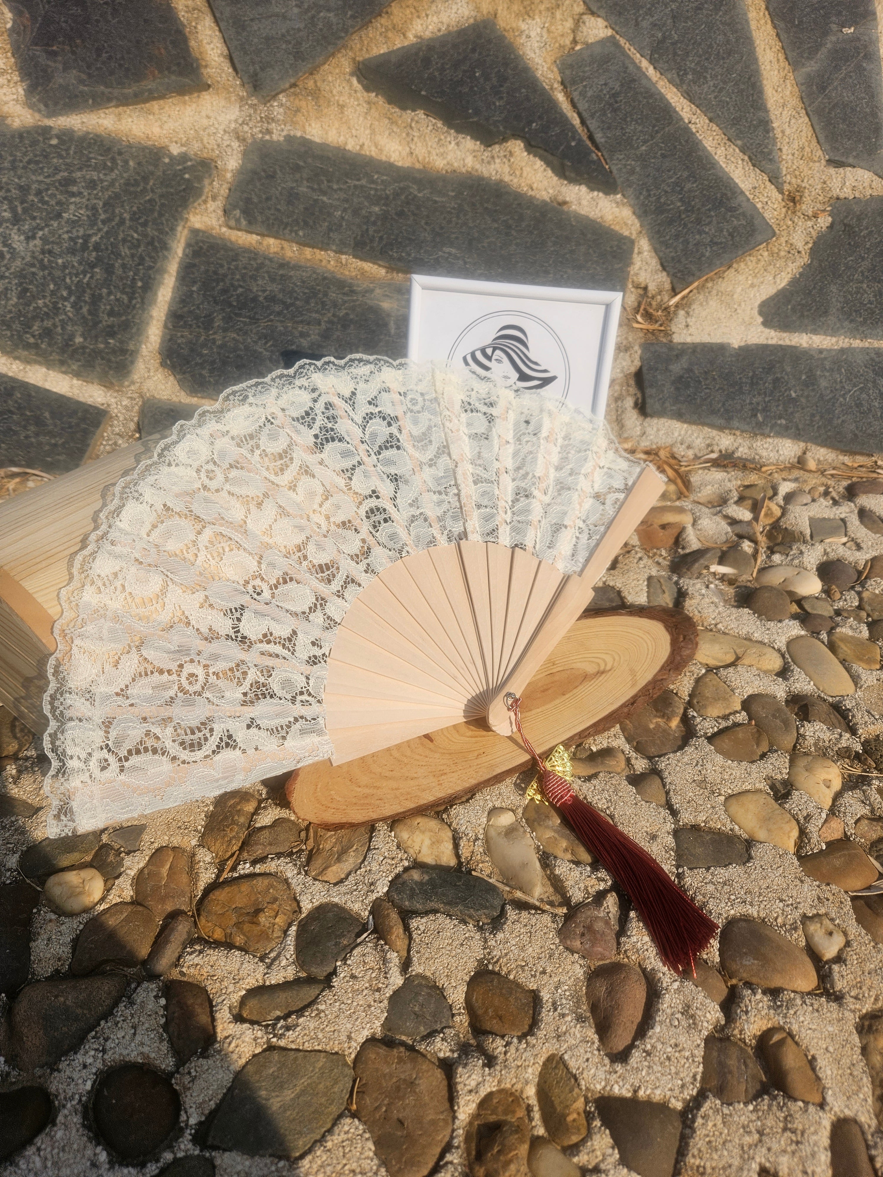 Abanico de madera con encaje blanco y borla granate con detalles dorados