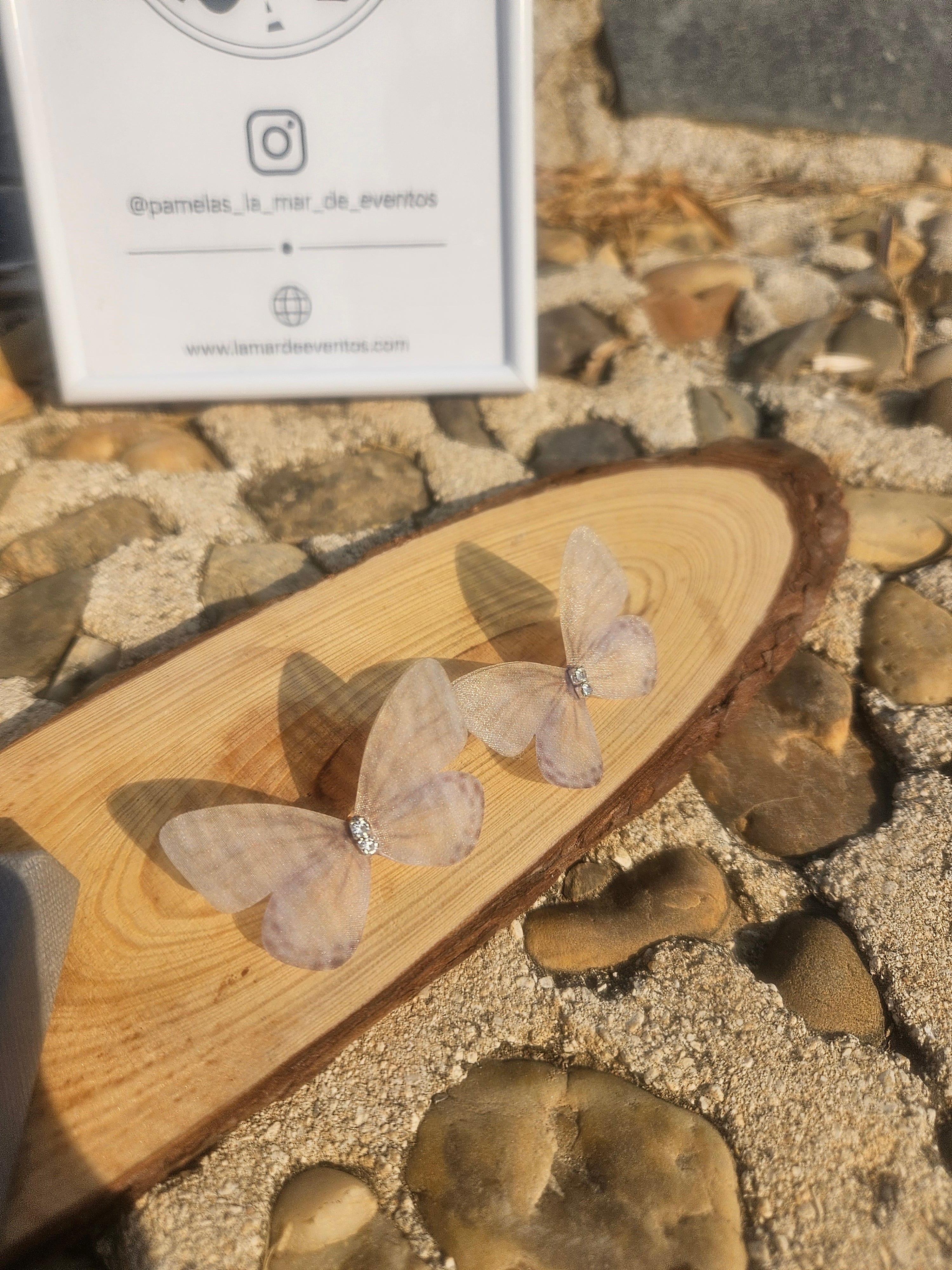 Pendientes Ayane con mariposas transparentes colocadas en soporte blanco