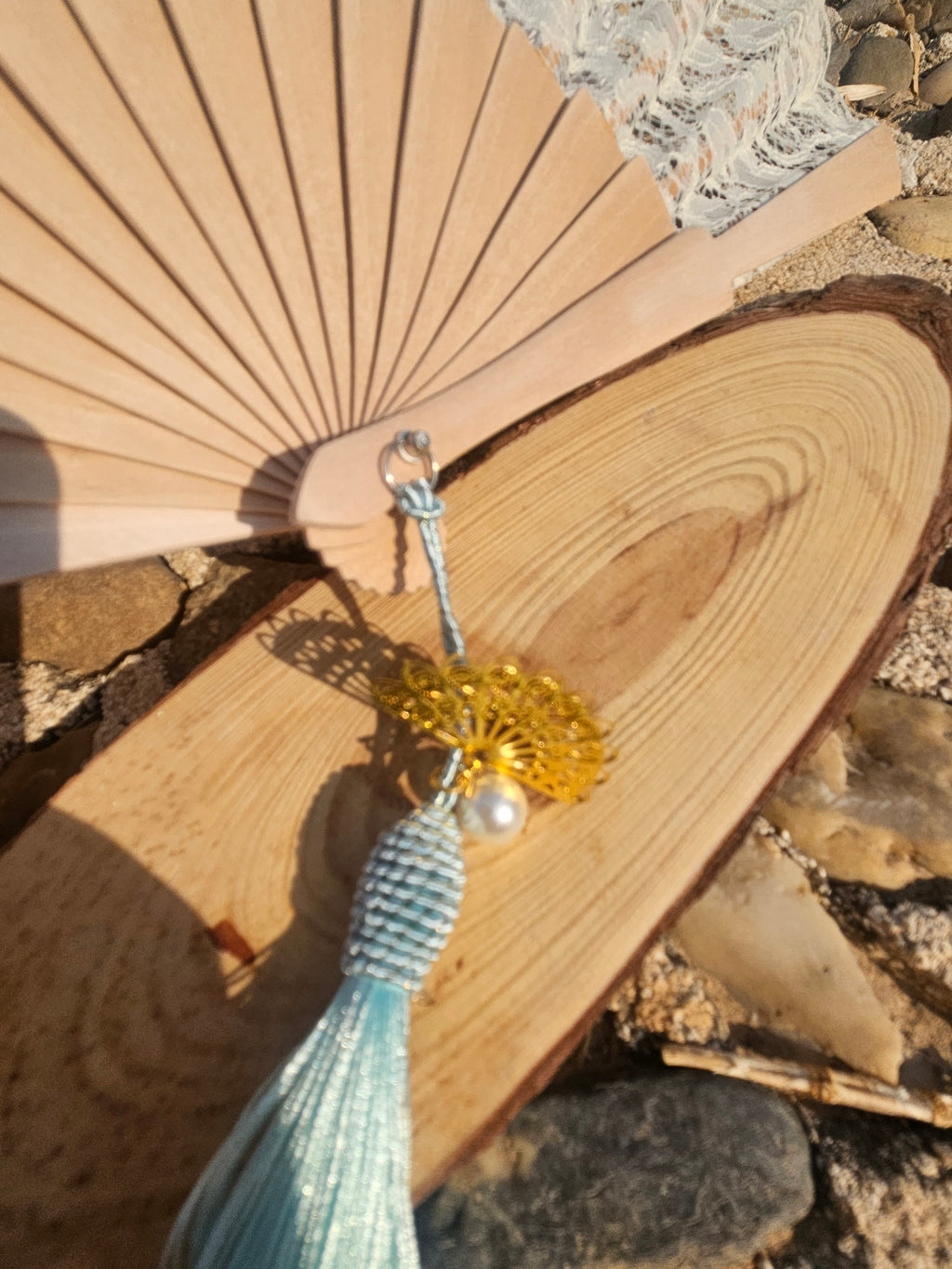 Abanico de madera con encaje blanco y borla turquesa con abalorios dorados