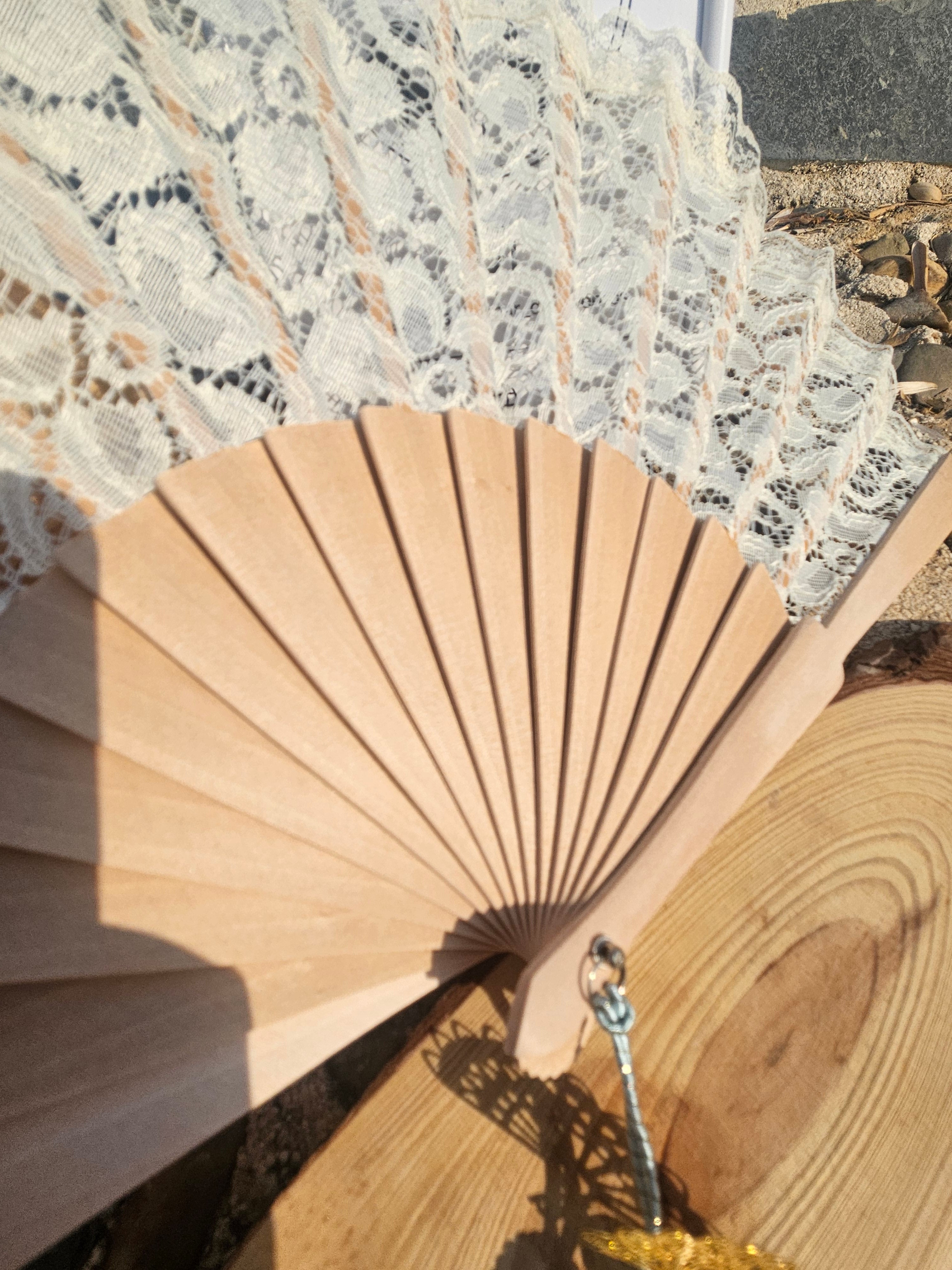 Abanico de madera natural con encaje blanco en la tela y borla turquesa