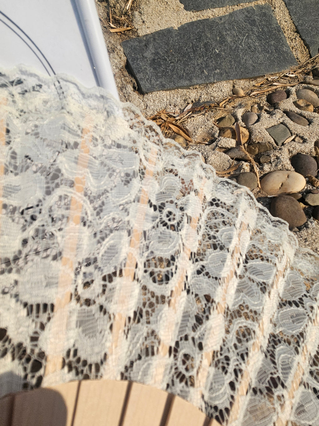 Abanico con encaje blanco y borde festoneado sobre varillas beige