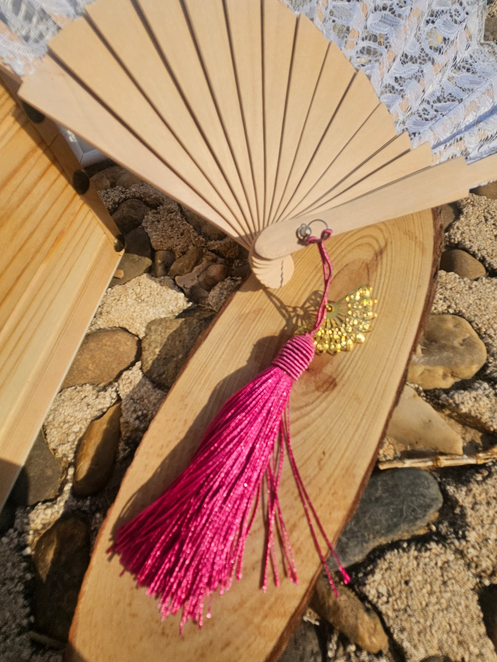 Abanico con varillas de madera y borla fucsia larga con colgantes pequeños