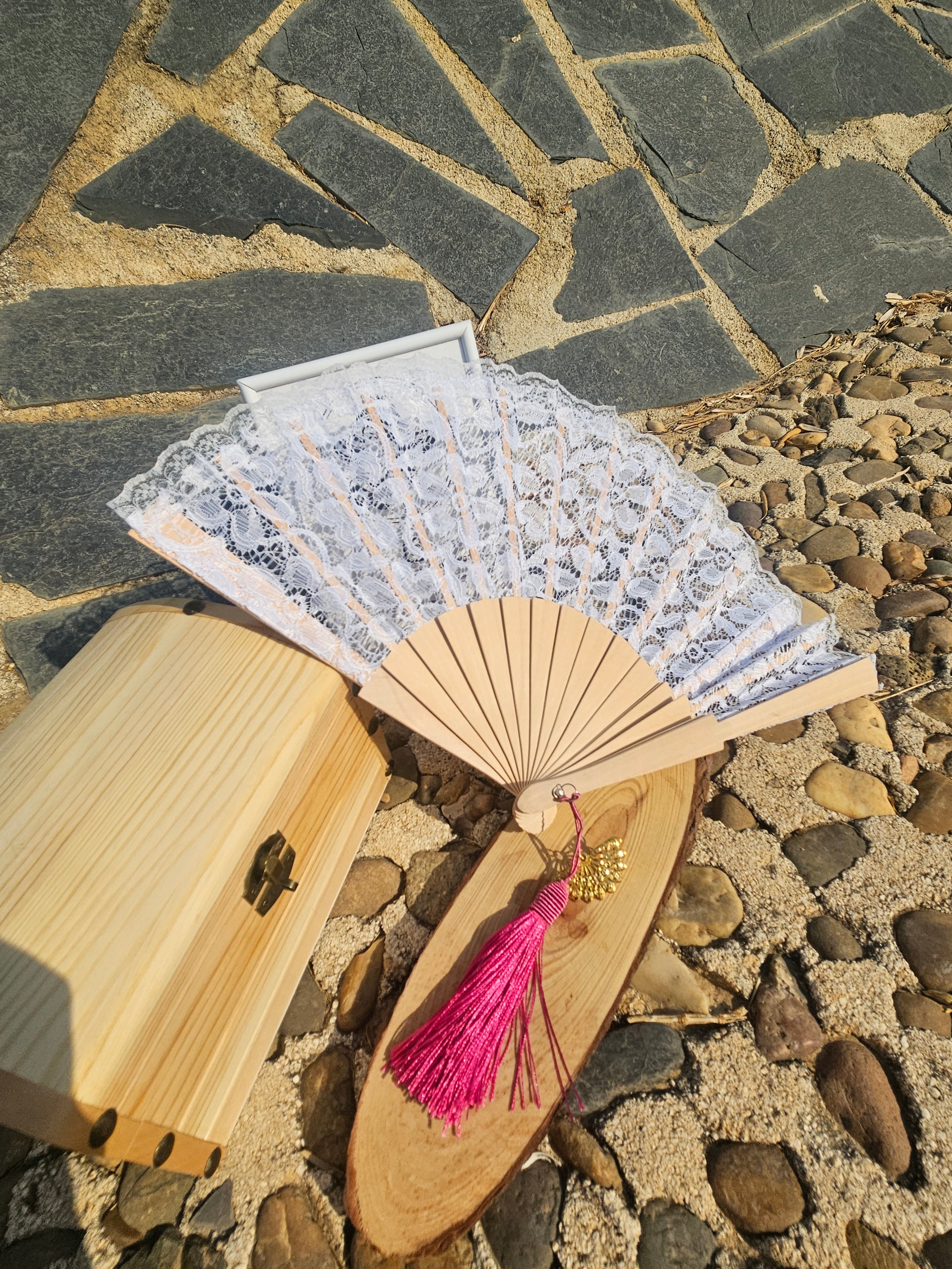 Abanico de encaje blanco con varillas de madera y borla fucsia colgante