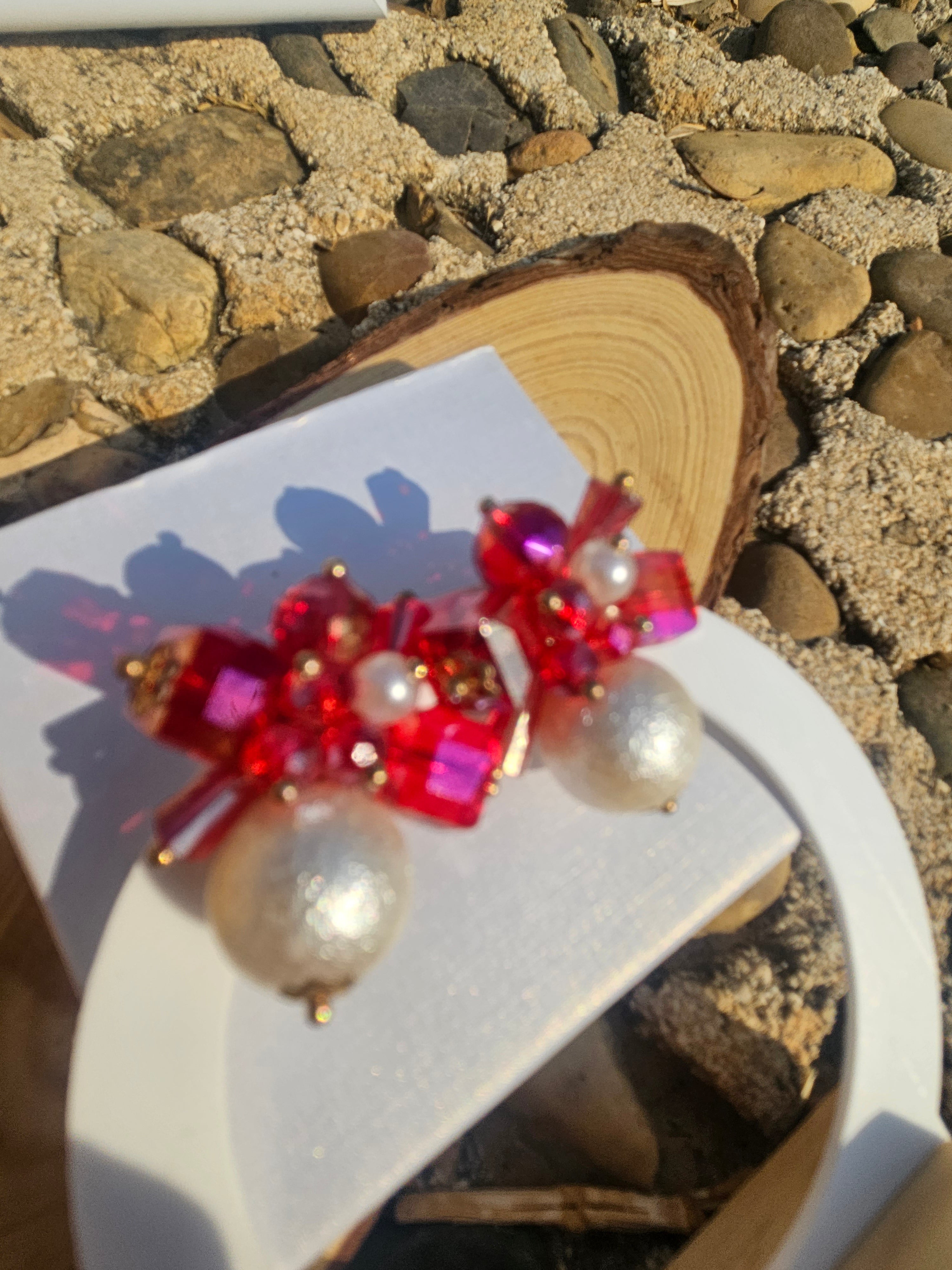 Pendientes con pedrería roja y perlas redondas, sin perder el detalle