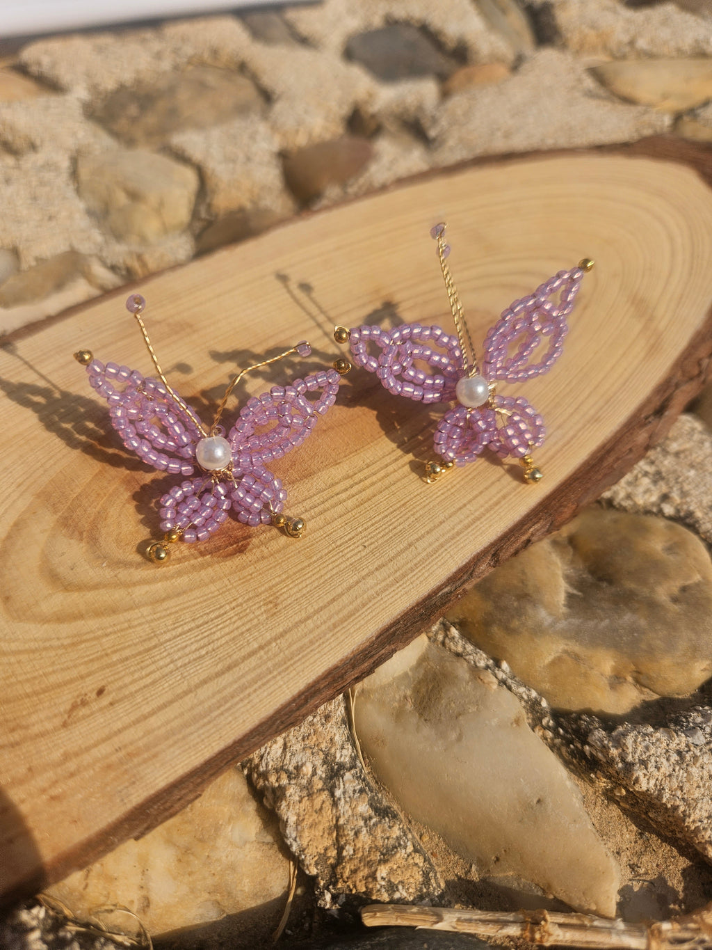 Par de pendientes con mariposas moradas de abalorios y perla central