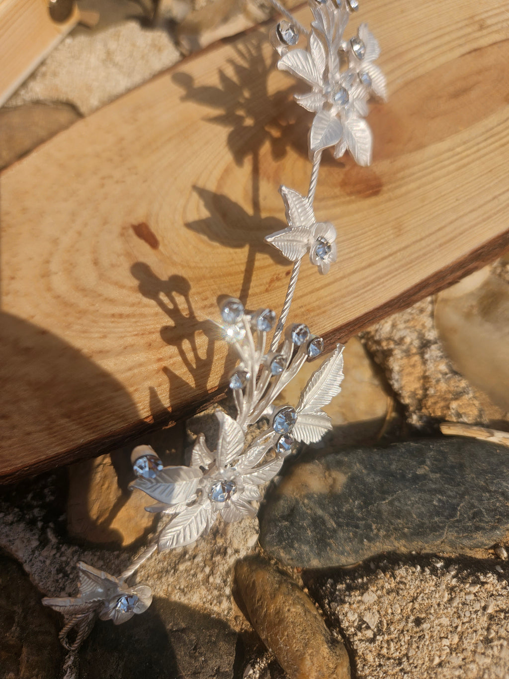 Tiara plateada con flores pequeñas y pedrería, detalle del centro