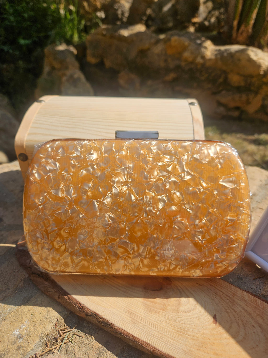 Bolso tipo clutch ámbar con textura efecto piel y cierre superior metálico