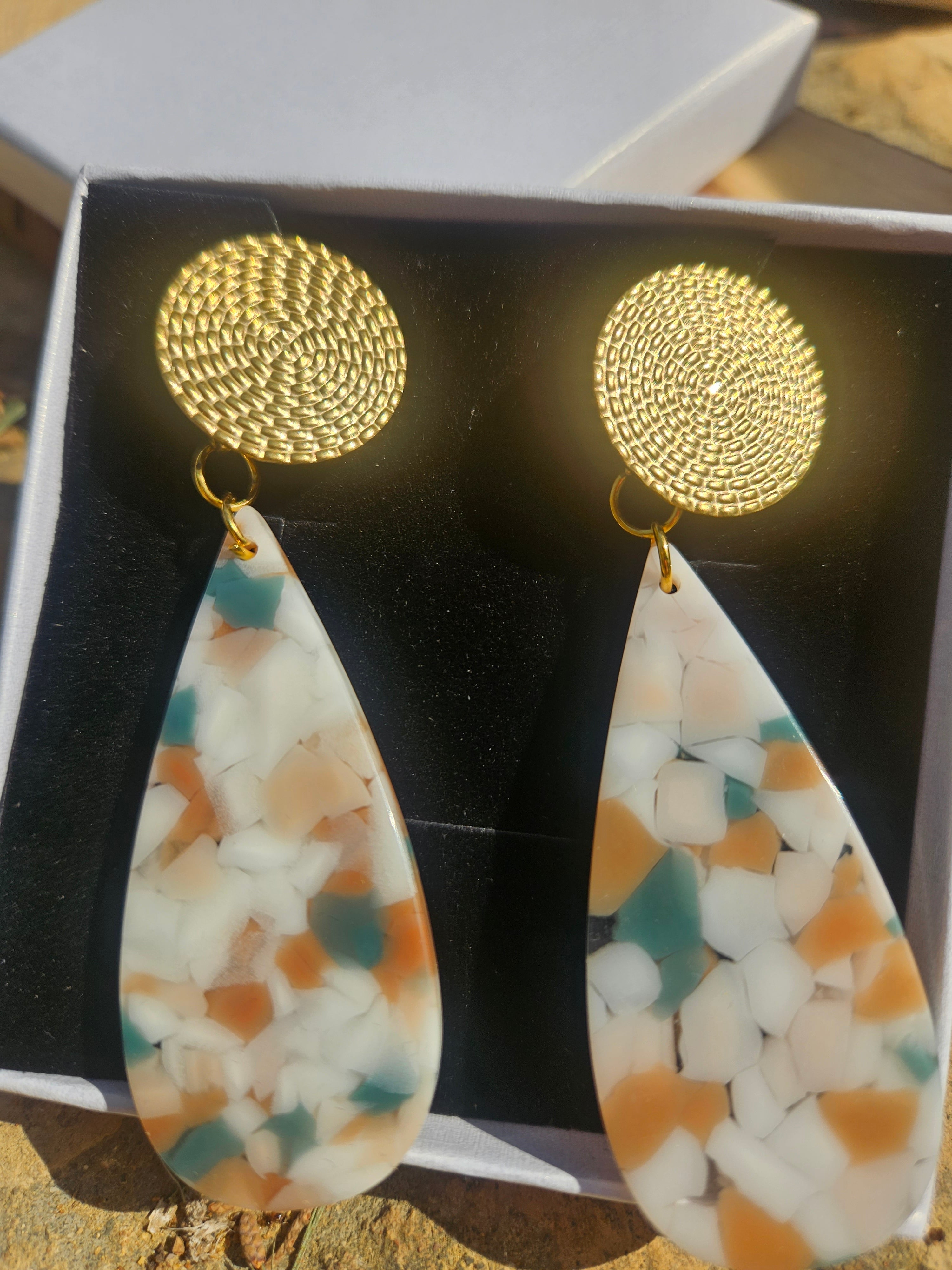 Pendientes con discos dorados y colgantes lágrima de resina multicolor, vista frontal