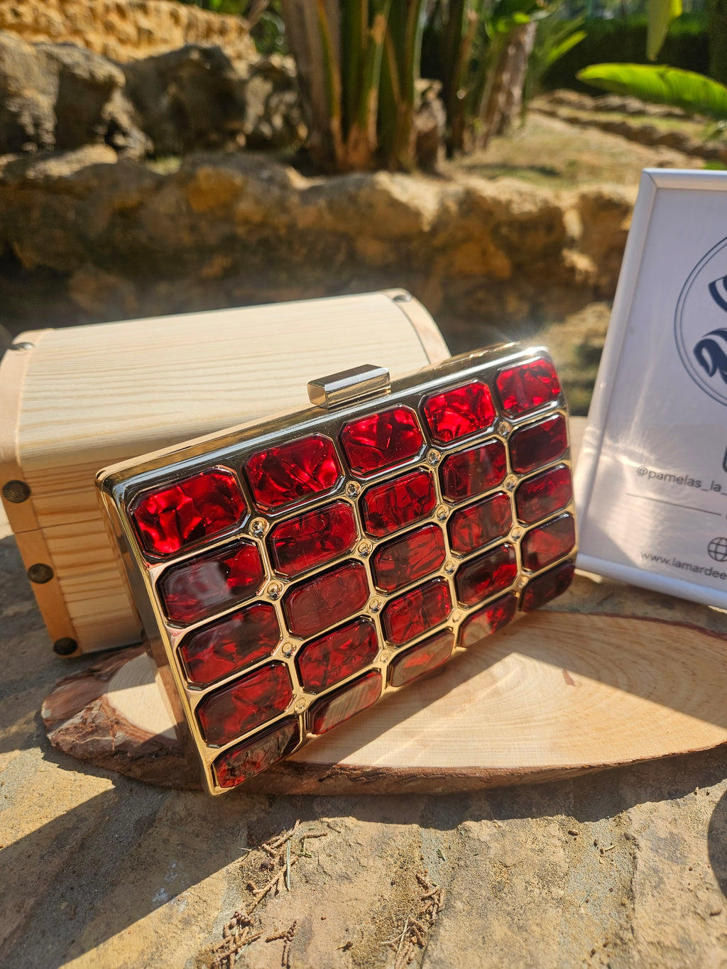Bolso tipo caja de madera clara con panel rojo brillante y broche superior plateado