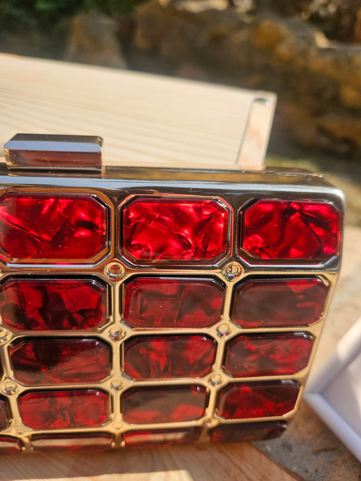 Bolso tipo caja: detalle del panel rojo con relieve de cuadrados y marco dorado