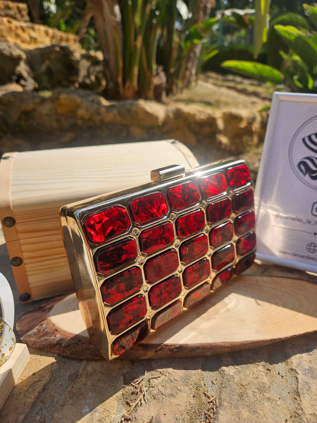 Bolso tipo caja de madera clara con panel frontal de rombos rojos y broche superior