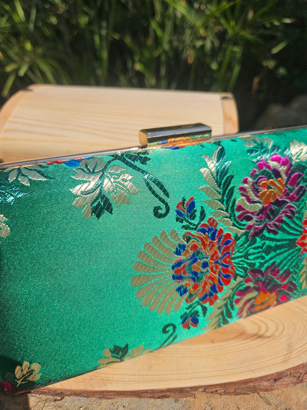 Bolso de mano verde con flores bordadas multicolor en la parte frontal y marco de madera