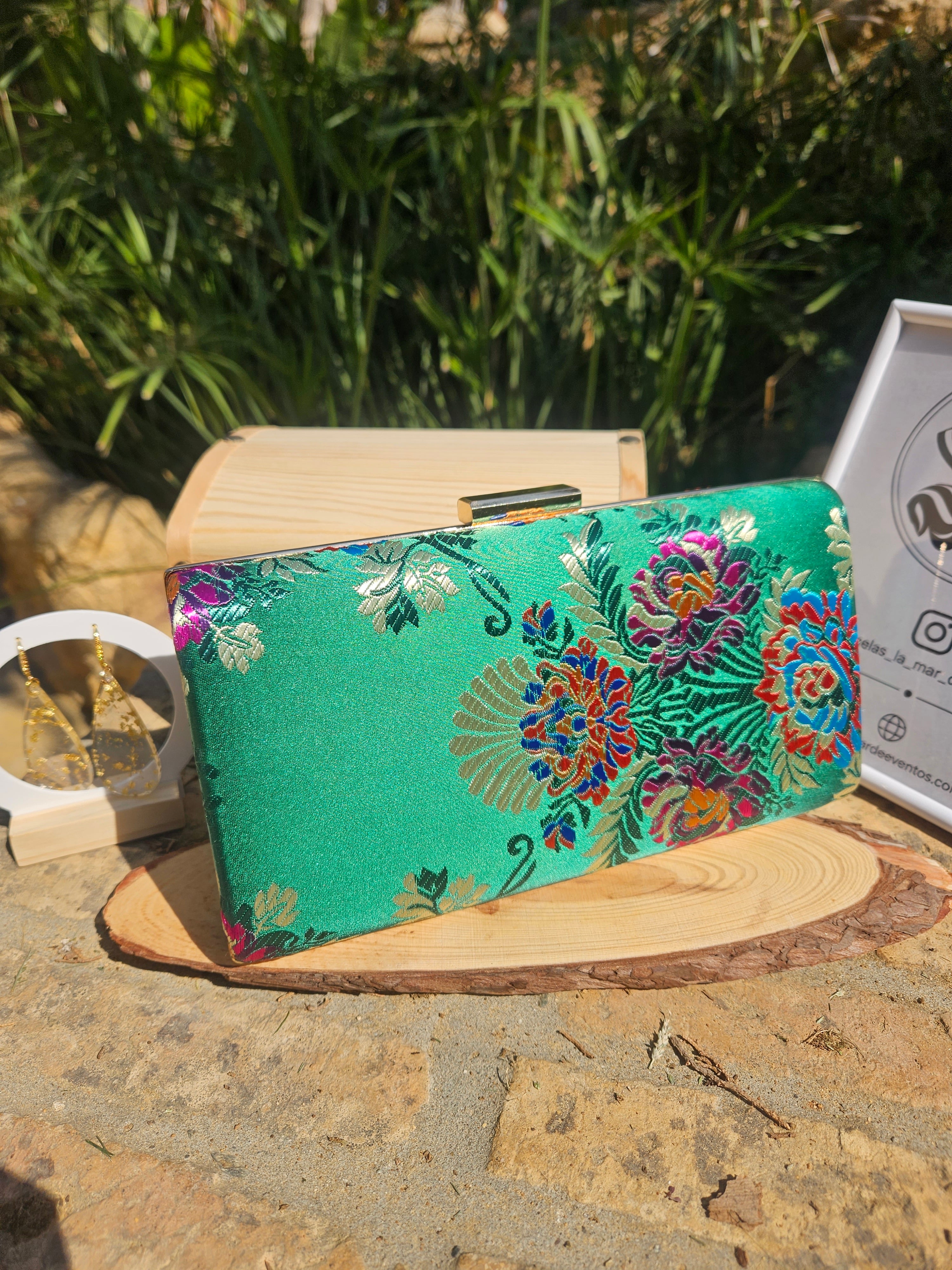 Bolso de mano verde con estampado floral multicolor y cierre superior de metal