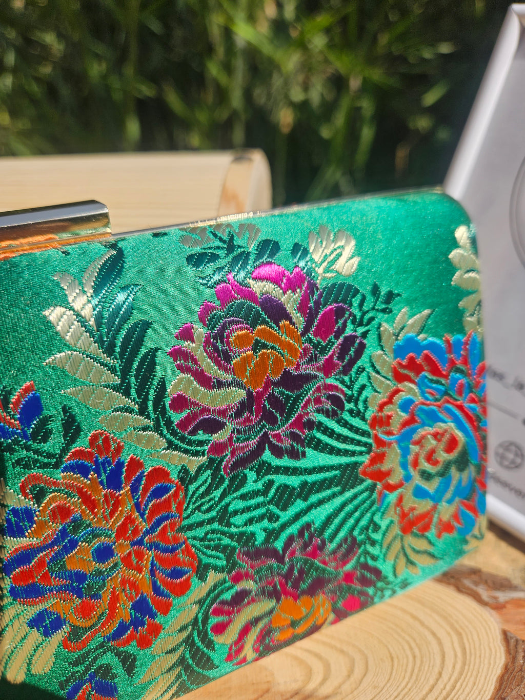 Bolso de mano verde con bordado floral detallado multicolor en el frente