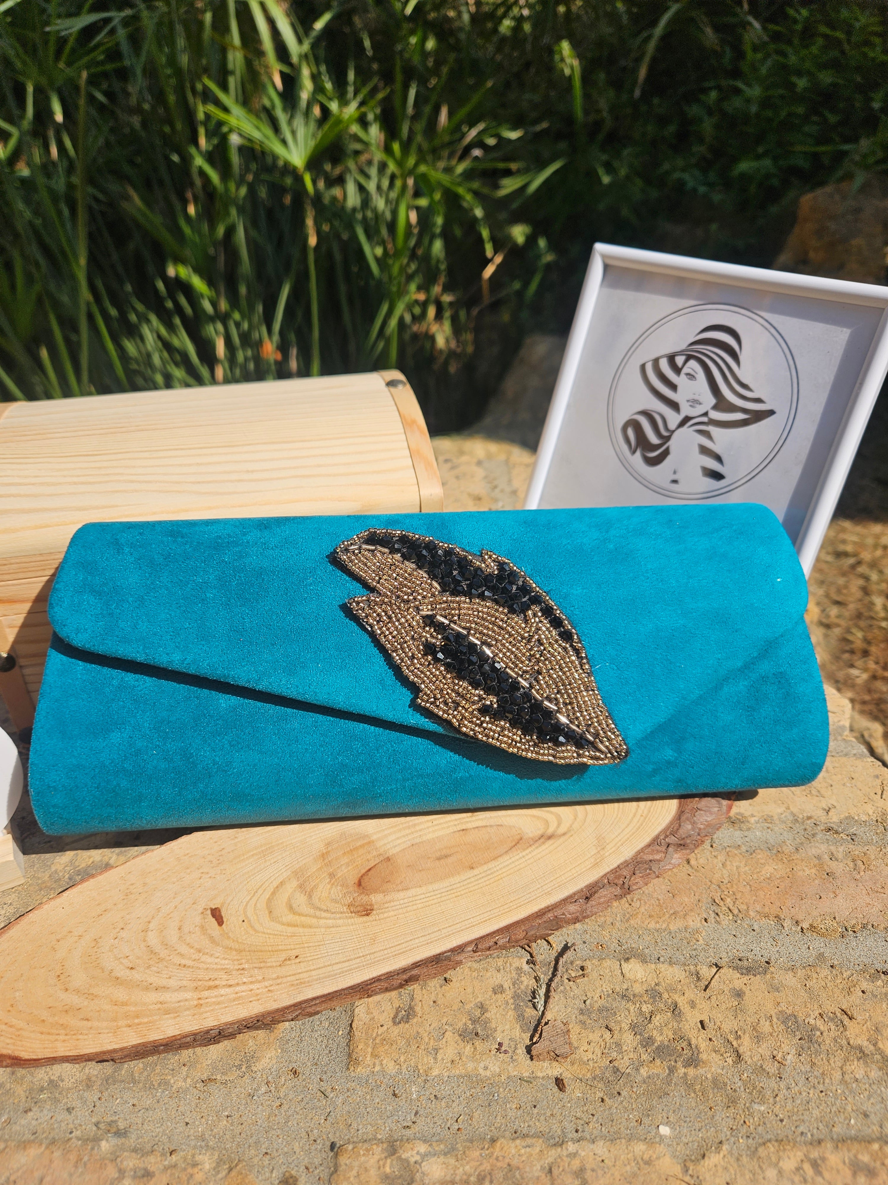 Bolso de ante turquesa con solapa y aplique bordado en forma de ojo