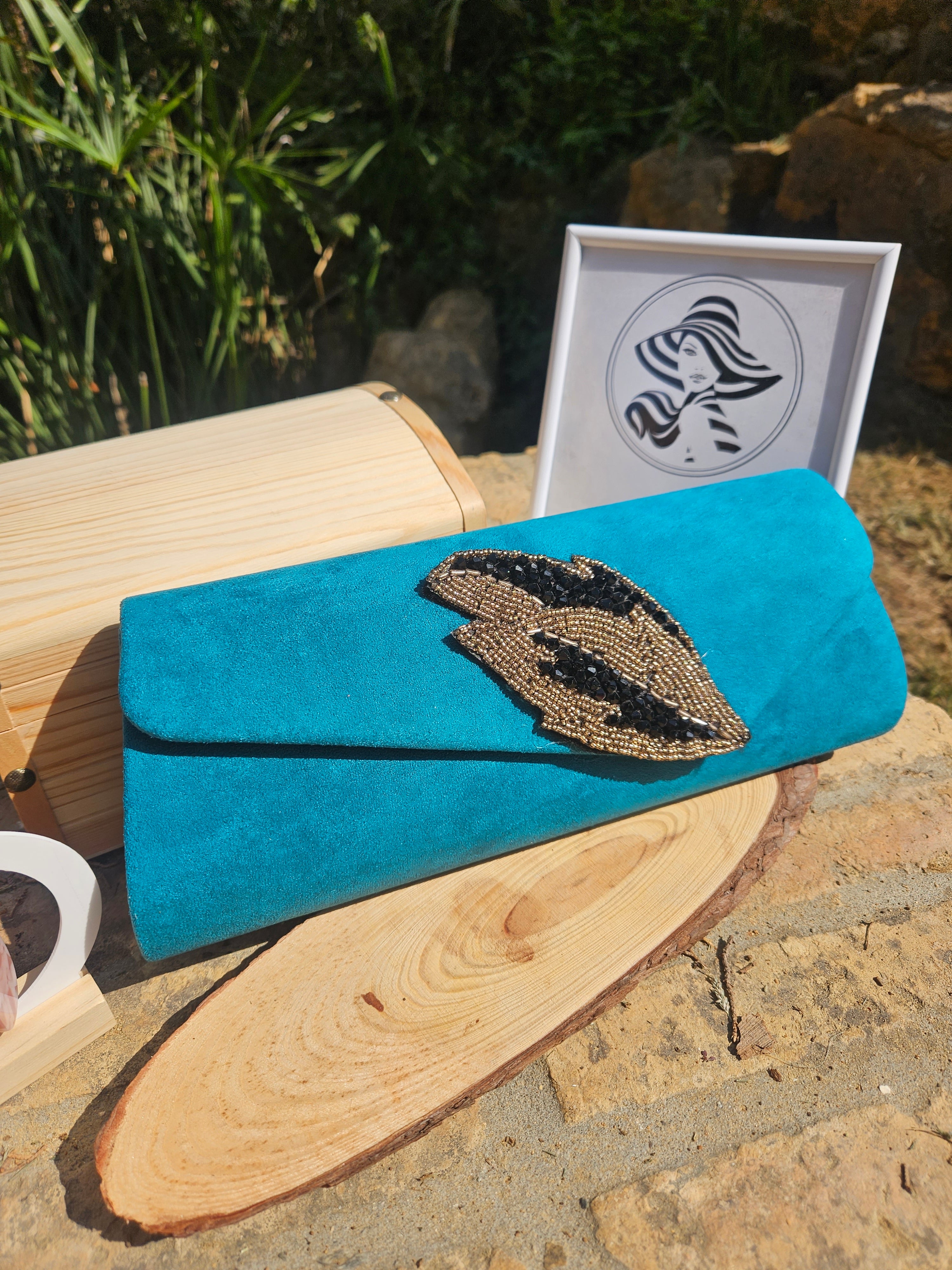 Bolso de ante turquesa con solapa curva y aplique bordado en forma de ojo