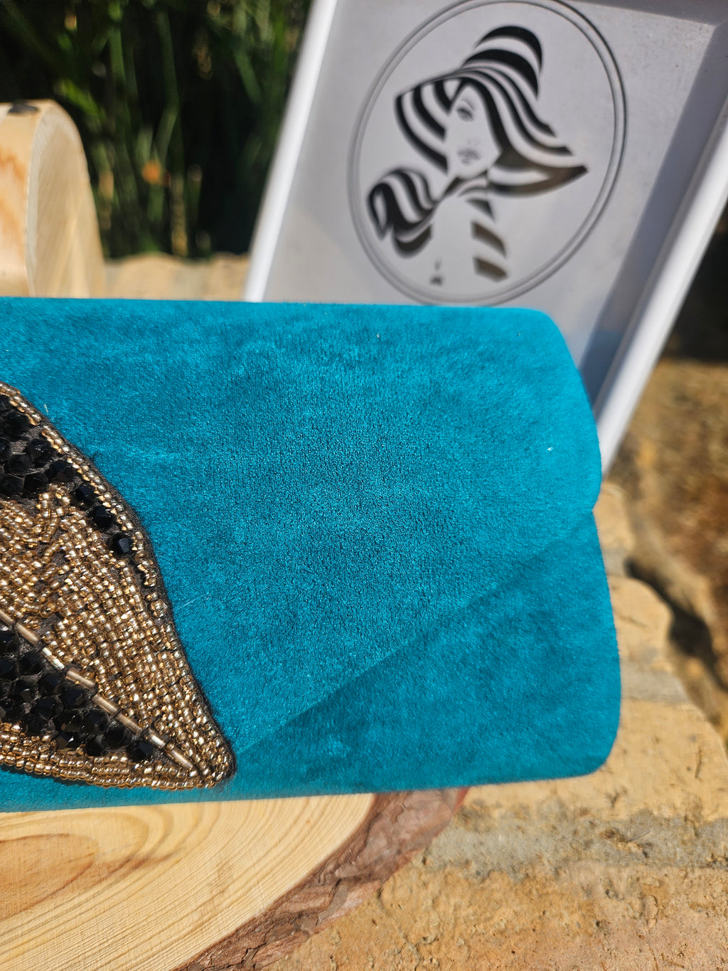 Bolso turquesa con solapa lisa y aplique bordado en forma de ojo con lentejuelas