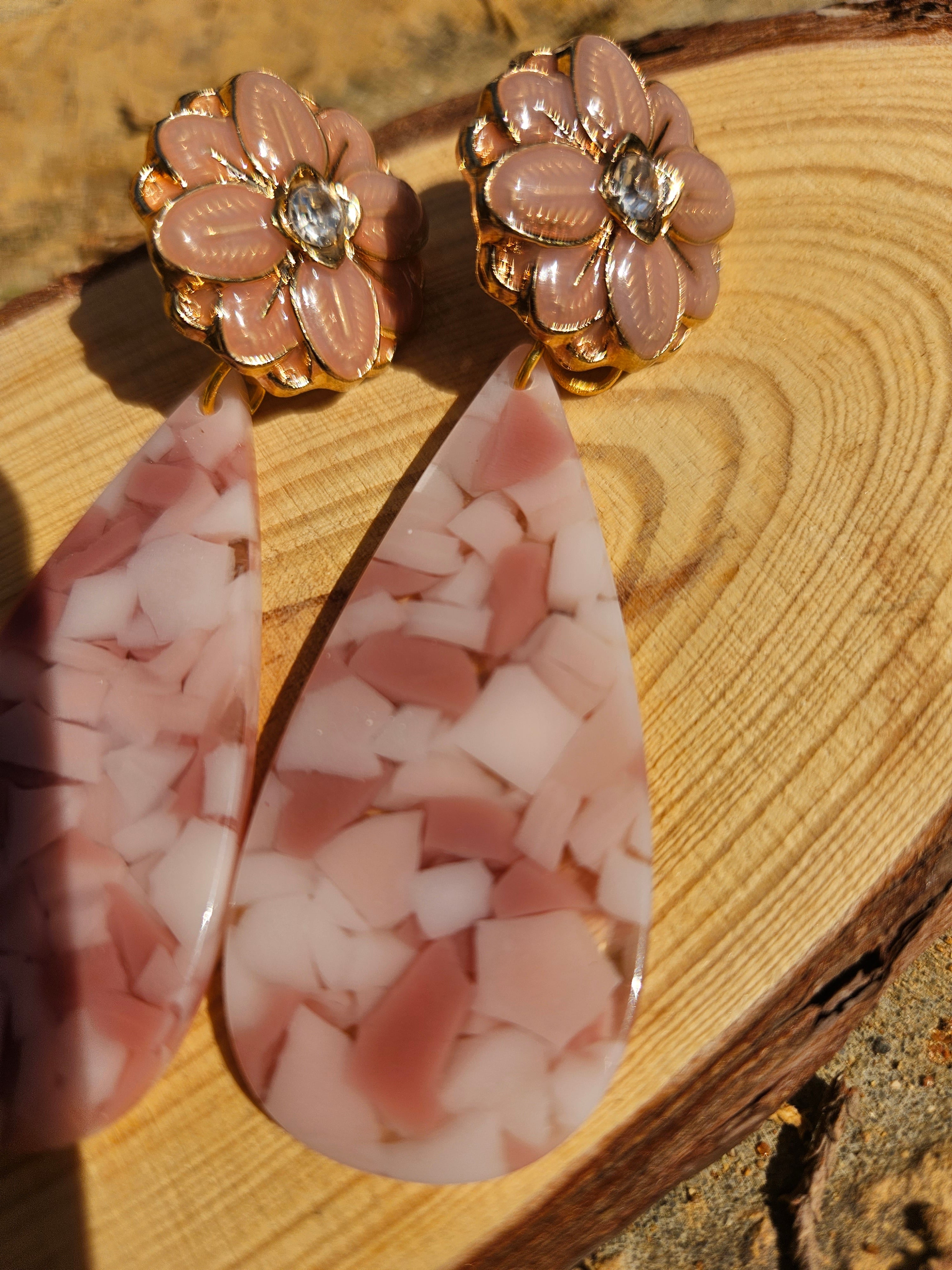 Pendientes florales dorados con colgantes gota rosa, textura jaspeada.