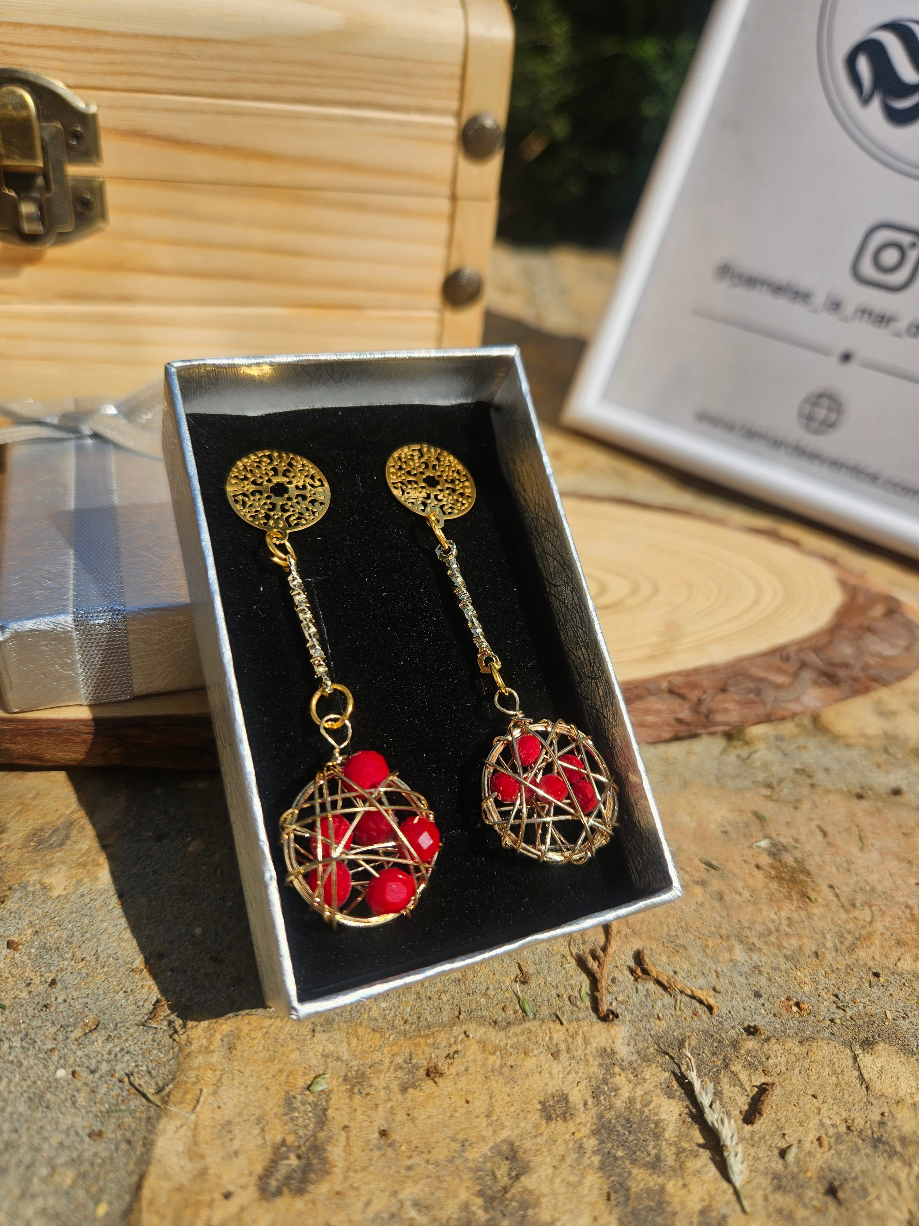 Pendientes colgantes Irv: discos dorados y esfera roja con malla metálica.