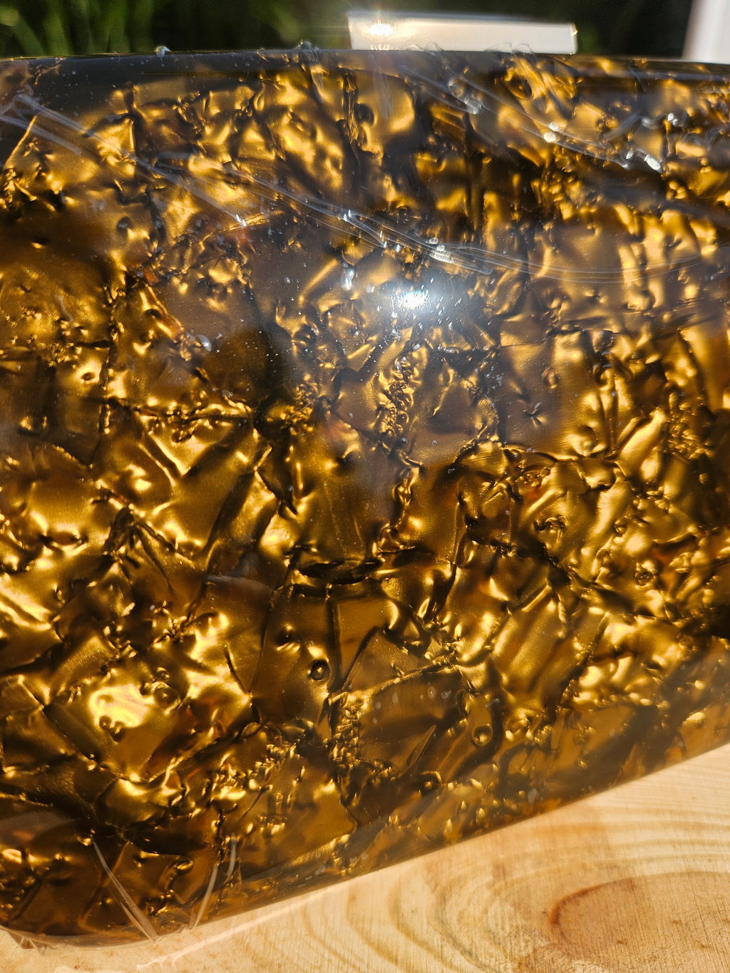 Bolso de mano dorado brillante en primer plano, textura tipo escamas dentro
